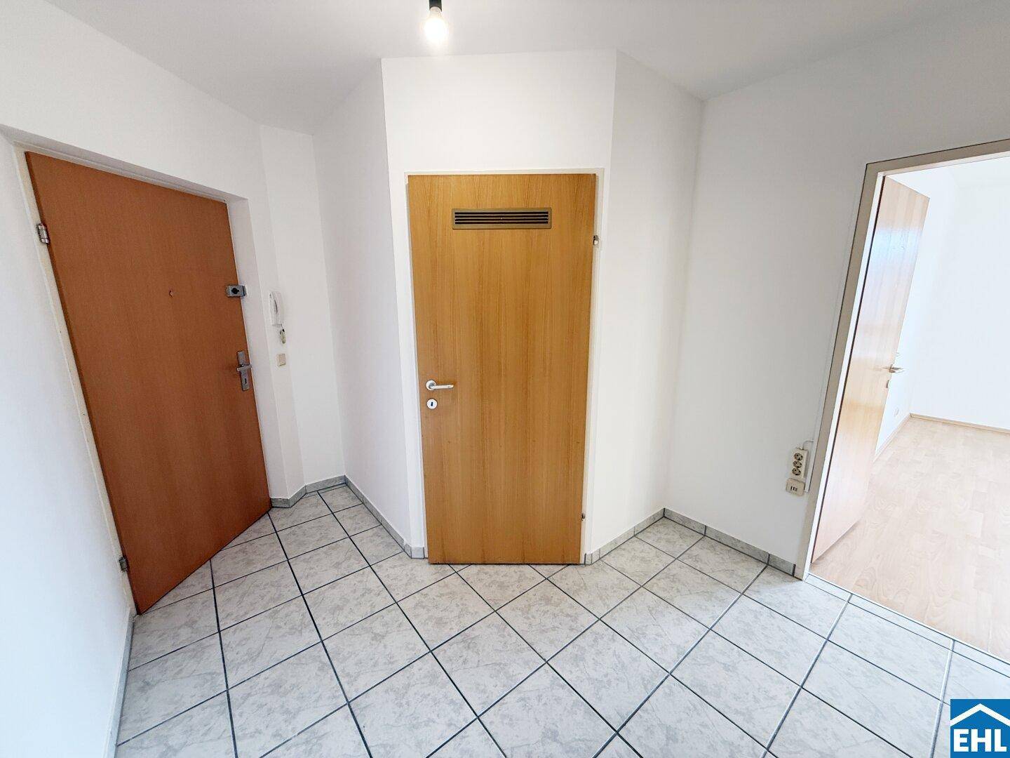 Geräumiger Flur mit Fliesenboden und mehreren Türen zu den angrenzenden Zimmern.