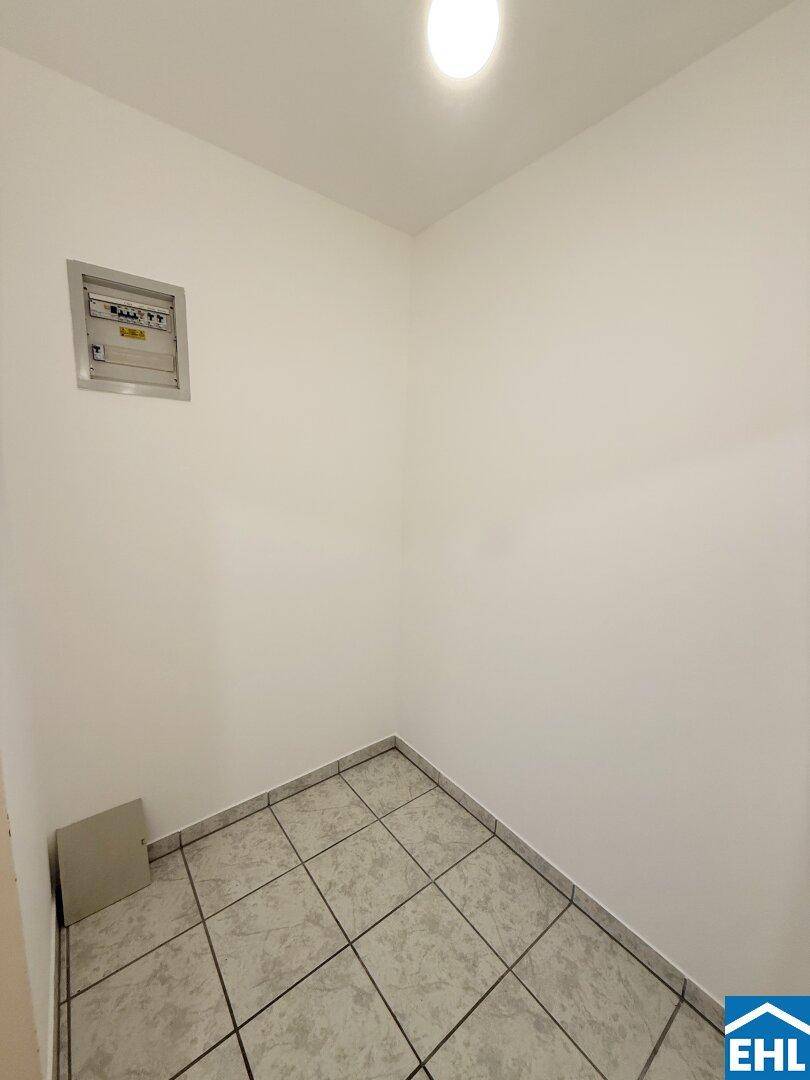 Praktischer Abstellraum mit Fliesenboden und Sicherungskasten für zusätzlichen Stauraum.
