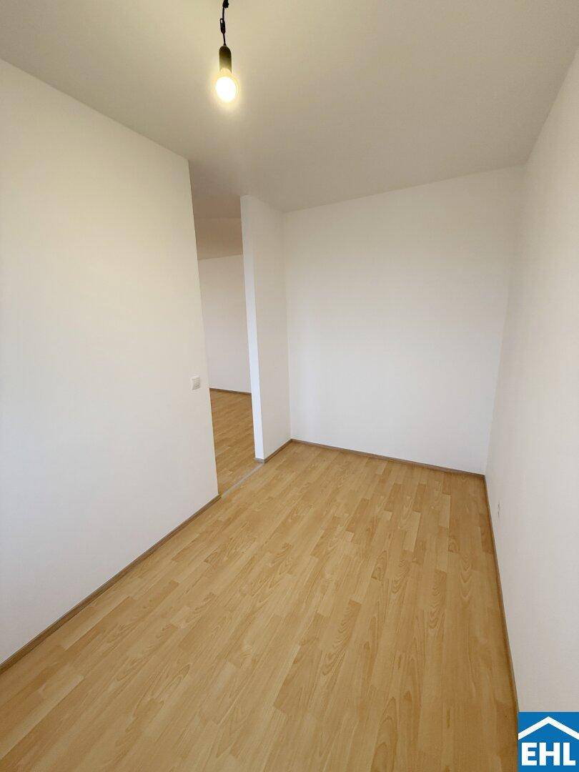 Heller Flur mit Laminatboden, der zu den verschiedenen Räumen der Wohnung führt.