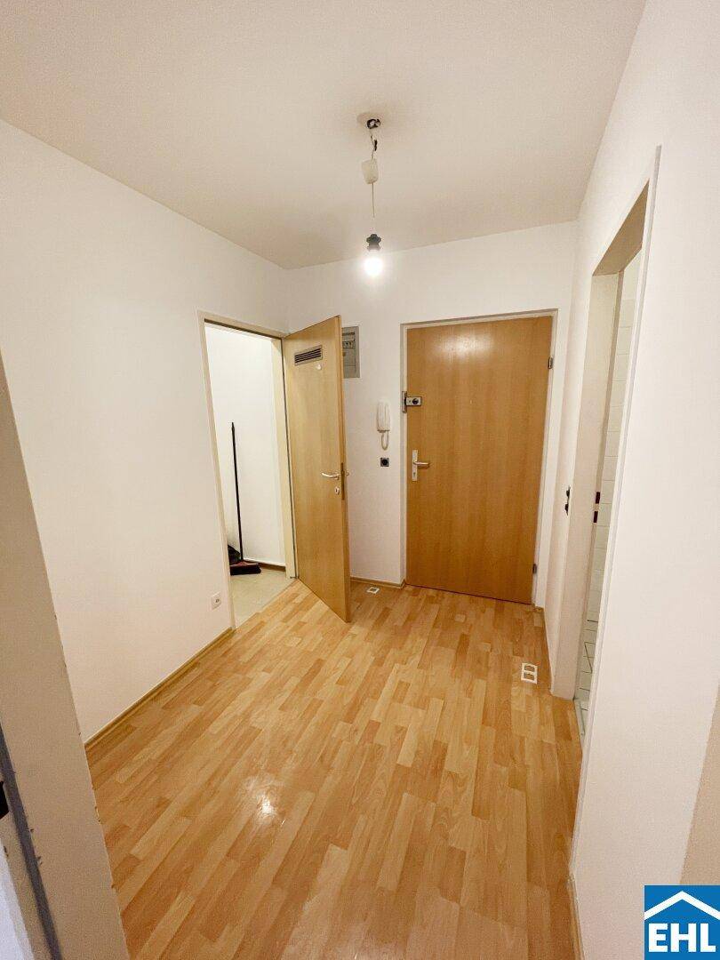 Heller Flur mit Laminatboden und Zugang zu verschiedenen Zimmern der Wohnung.