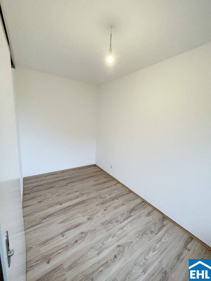 Kleinerer Raum mit Laminatboden und weißen Wänden, ideal als Schlaf- oder Arbeitszimmer.