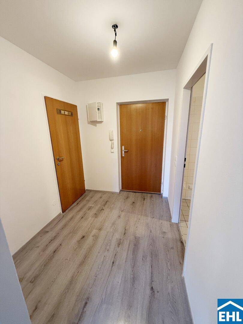 Heller Flur mit Laminatboden und mehreren Türen, der die verschiedenen Räume verbindet.