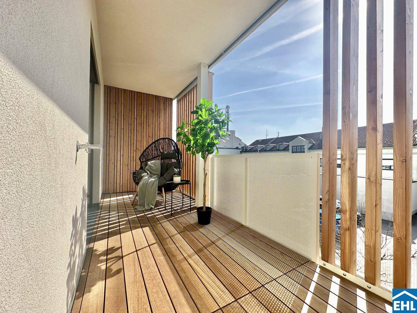 Heller Balkon mit Holzverkleidung, Holzboden und Blick auf die Umgebung.