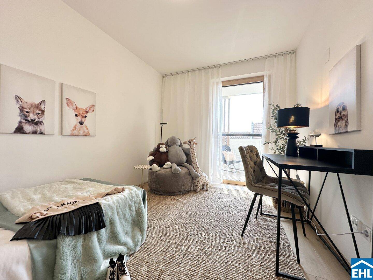 Helles Kinderzimmer mit Schreibtisch, Stuhl und Zugang zu einem Balkon.