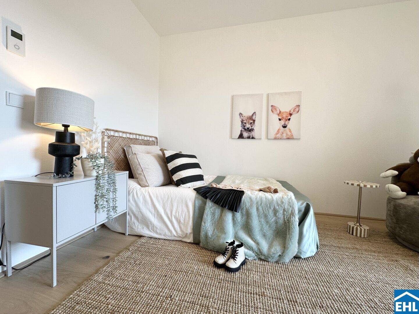Gemütliches Kinderzimmer mit Einzelbett, Teppich und Tierbildern an der Wand.