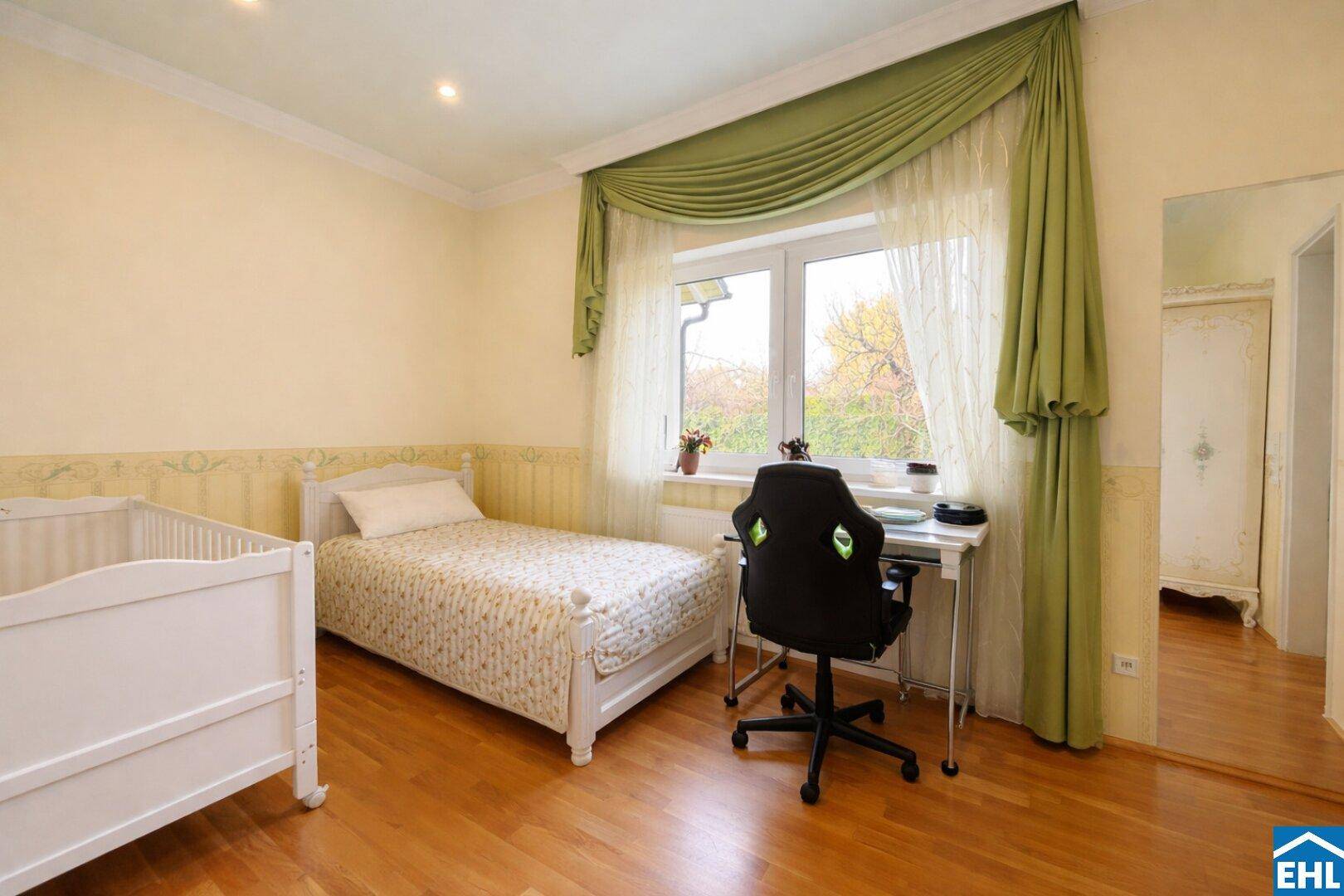 Kinderzimmer mit Parkettboden, Einzelbett und Babybett, ideal für junge Familien.