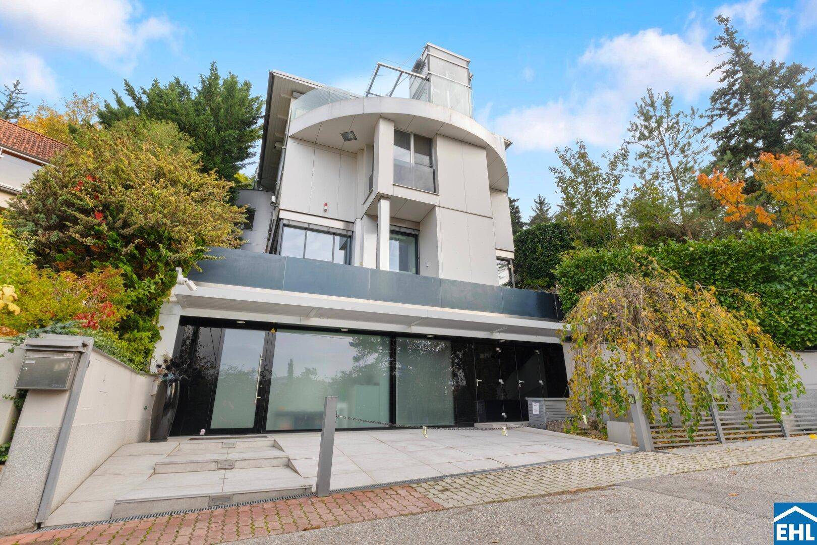 Moderne Fassade der Villa von der Straße aus gesehen mit Garage und elegantem Eingangsbereich.