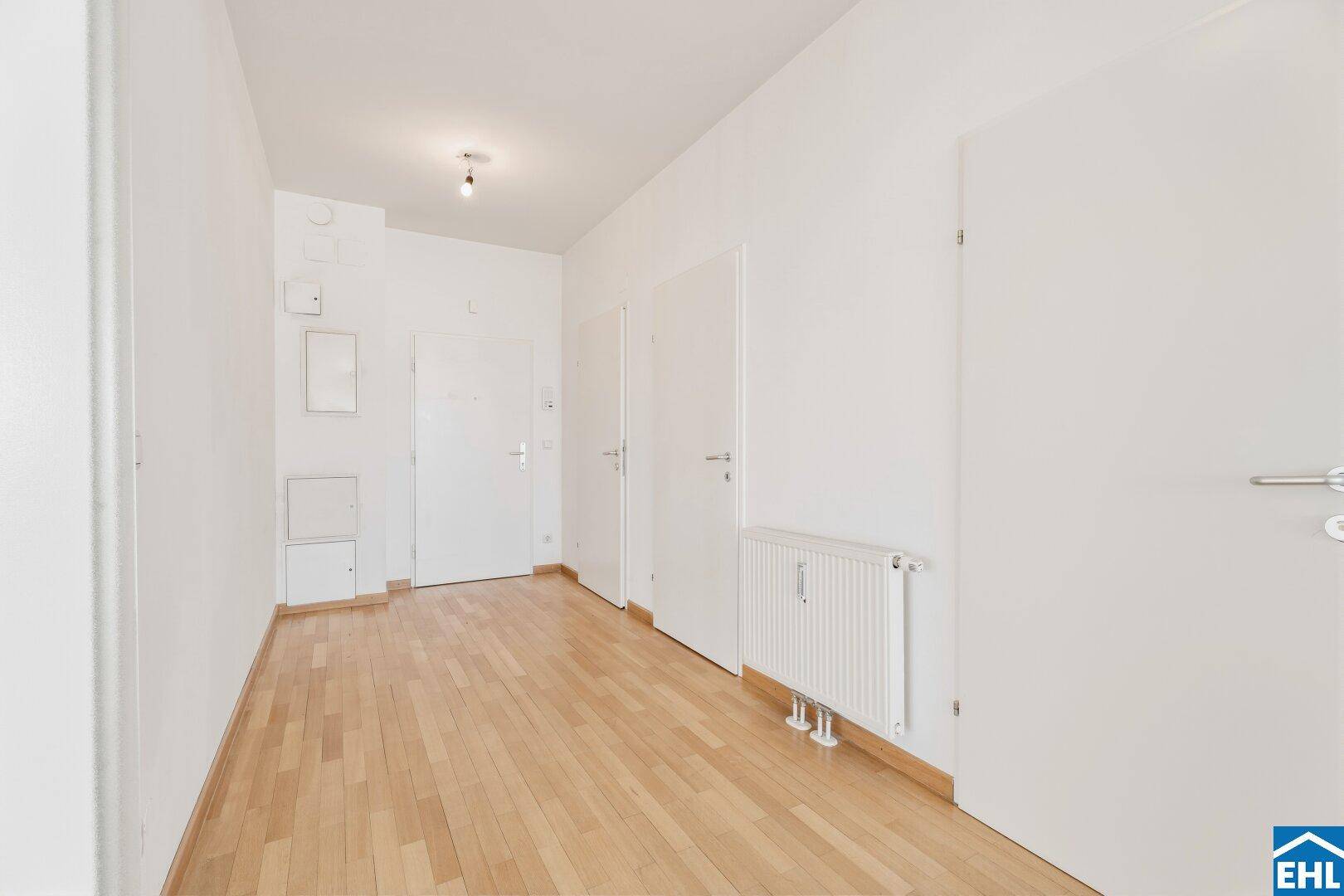 Heller Flur mit Parkettboden und weißen Türen.