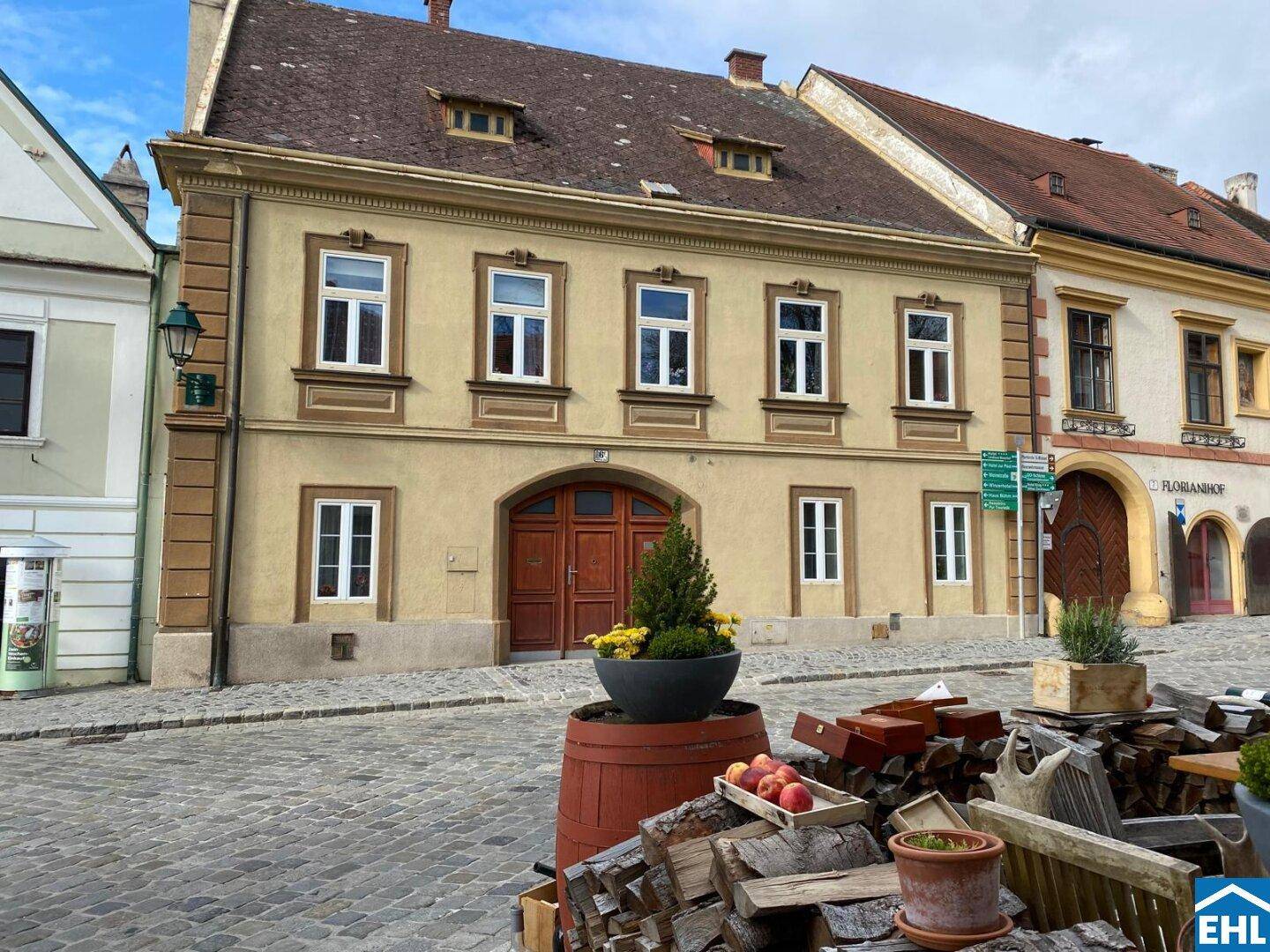 Historische Fassade eines Gebäudes an einer gepflasterten Straße in einer charmanten Altstadt.