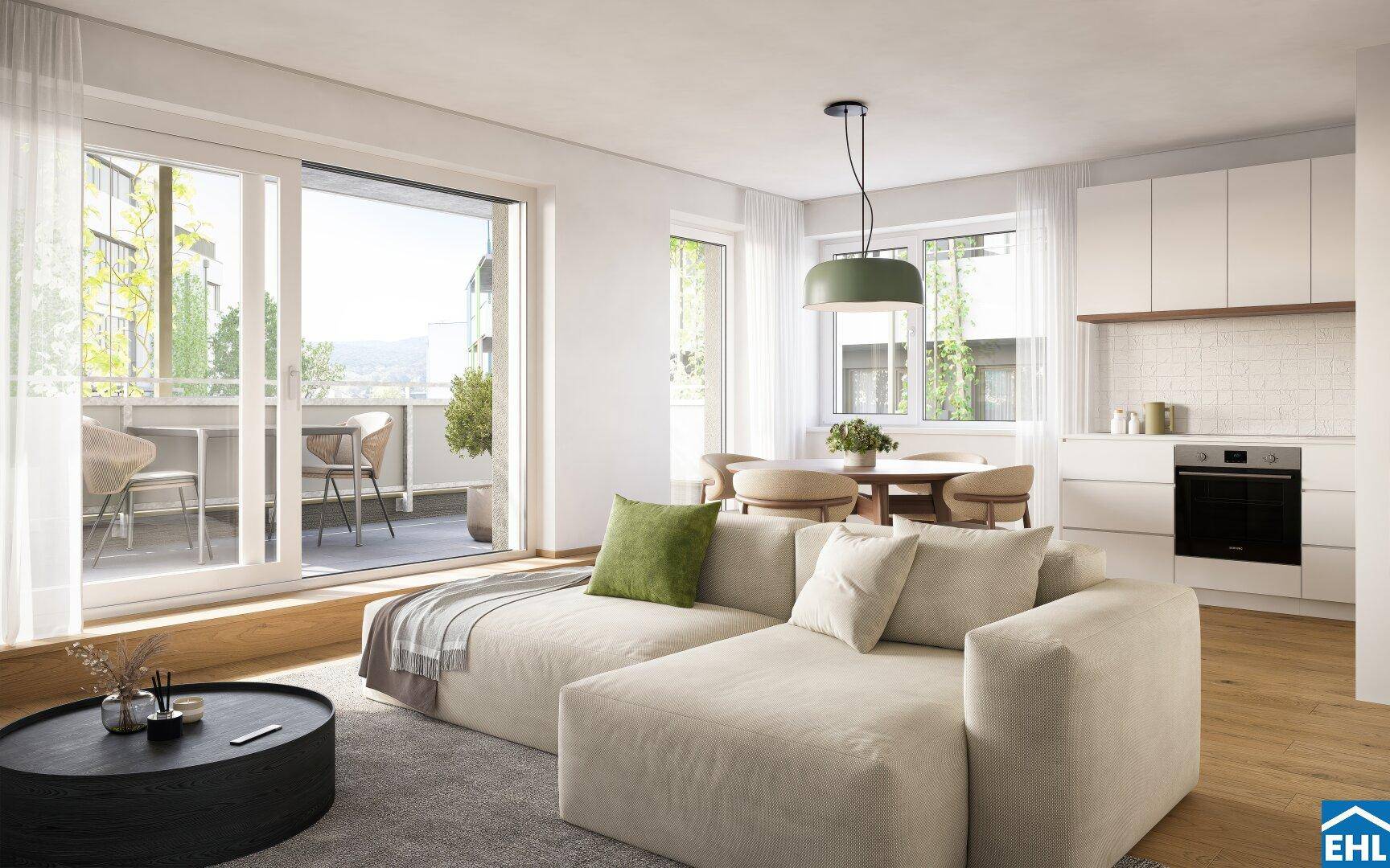 Heller offener Wohnbereich mit integrierter Küche, Essplatz und Zugang zum Balkon.