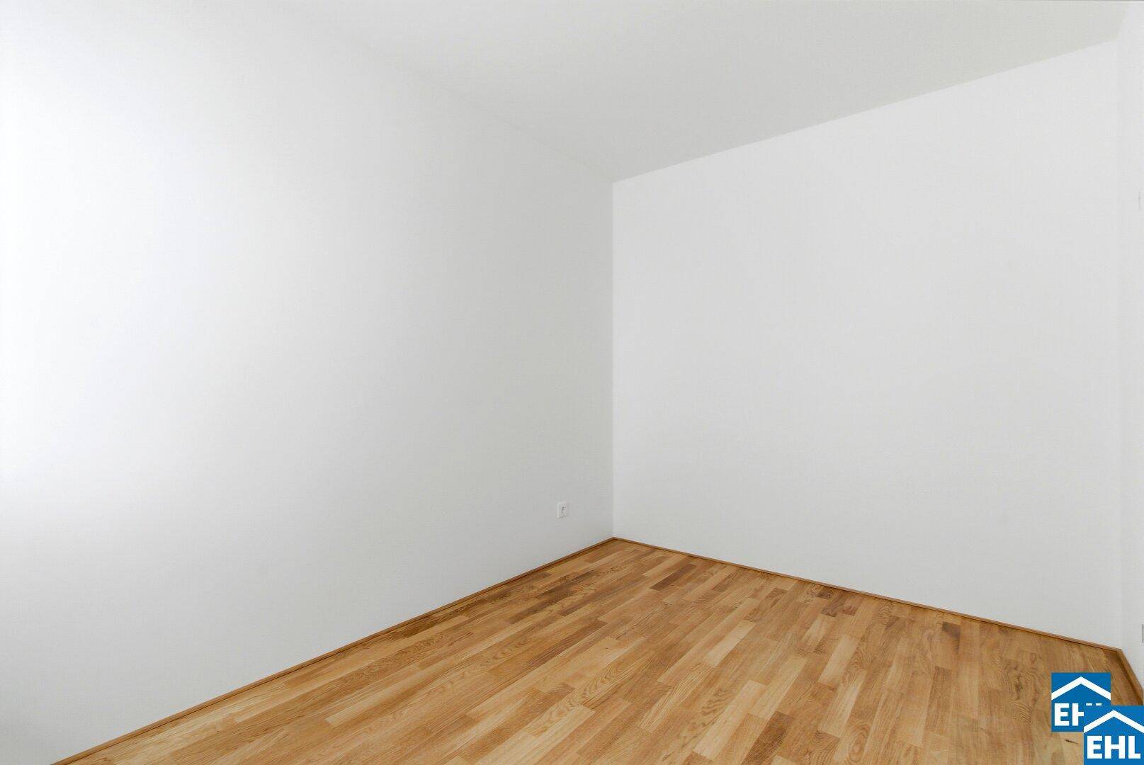 Leeres Zimmer mit Parkettboden und weißen Wänden, bietet vielseitige Nutzungsmöglichkeiten.