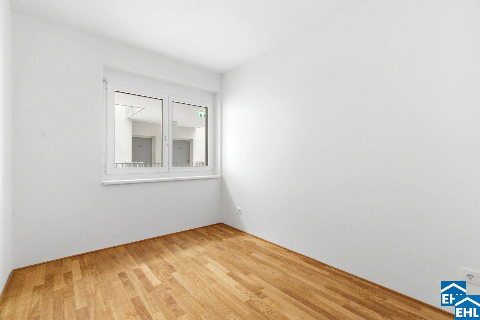 Helles Zimmer mit Parkettboden und Fenster, ideal als Schlaf- oder Arbeitszimmer.