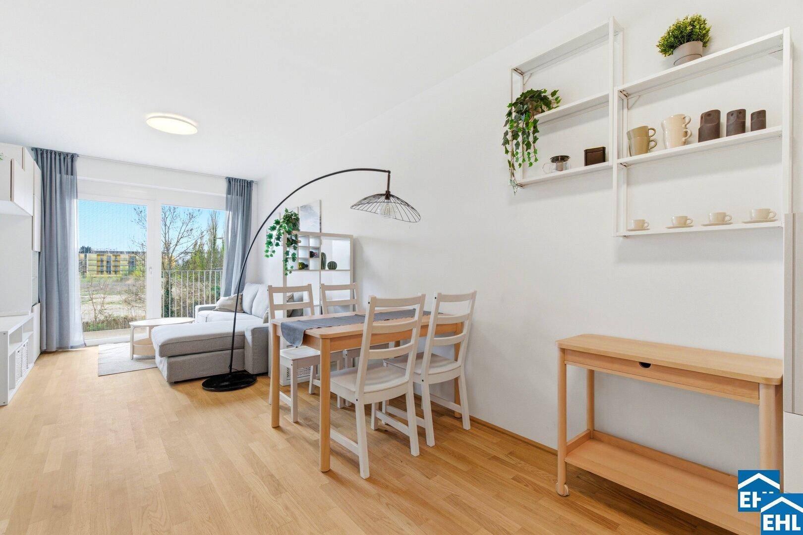 Geräumiger Wohn-Essbereich mit Holzboden, modernem Esstisch und Regalen.