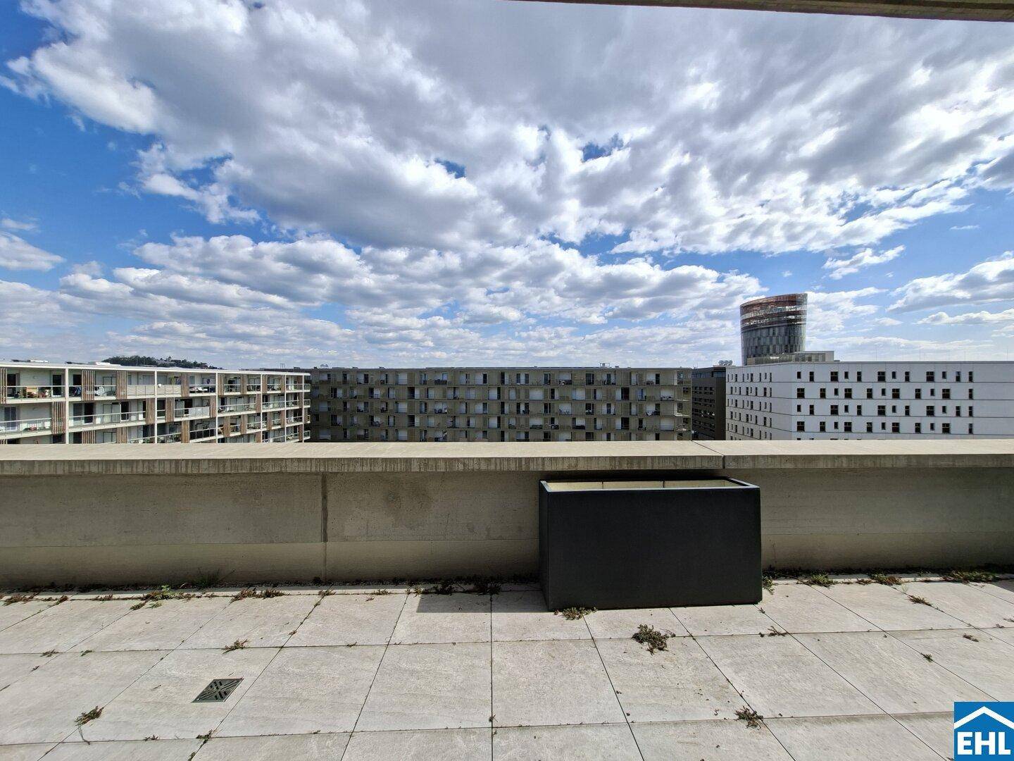 Geräumige Dachterrasse mit Fliesenboden und weitem Blick über die umliegenden Gebäude.