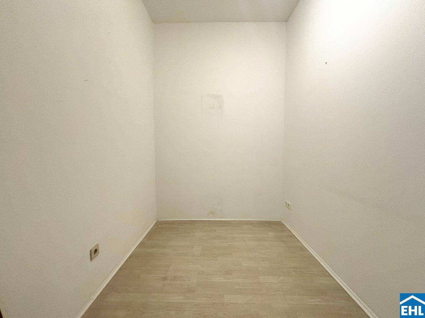 Kleiner, leerer Raum mit hellem Laminatboden, ideal als Abstellkammer oder begehbarer Kleiderschrank.