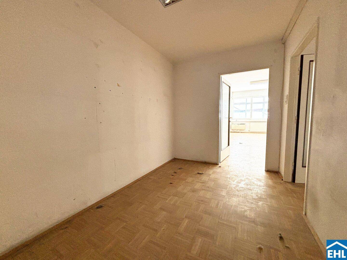 Heller Flur mit Parkettboden und Zugang zu weiteren Räumen.