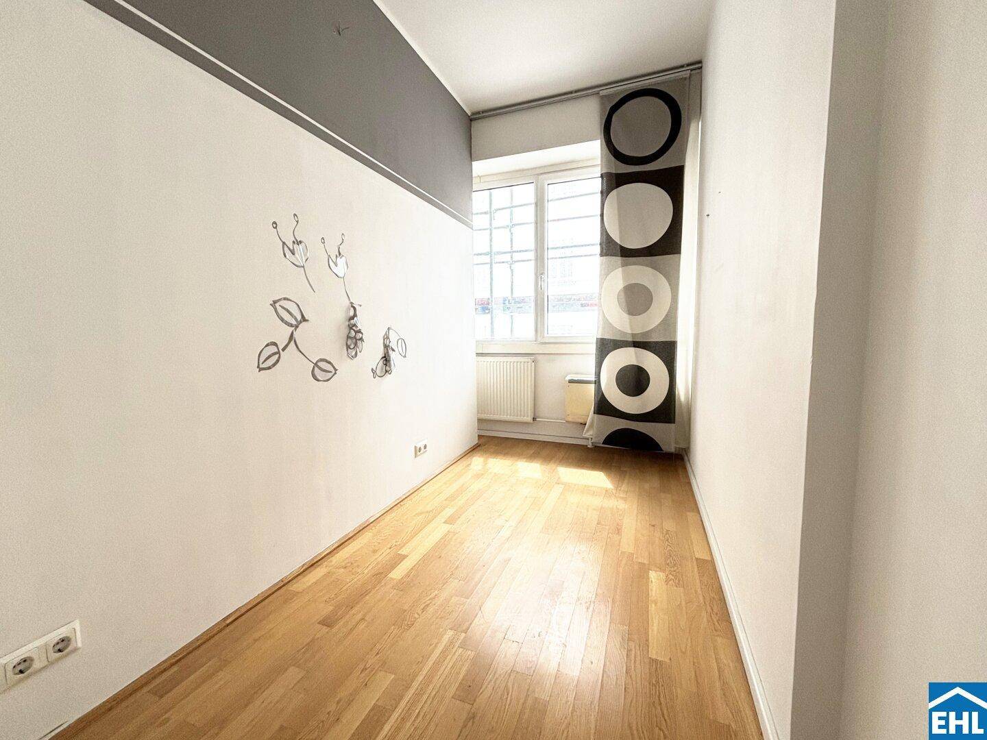Helles Zimmer mit Parkettboden und Fenster, ideal als Schlaf- oder Arbeitszimmer nutzbar.