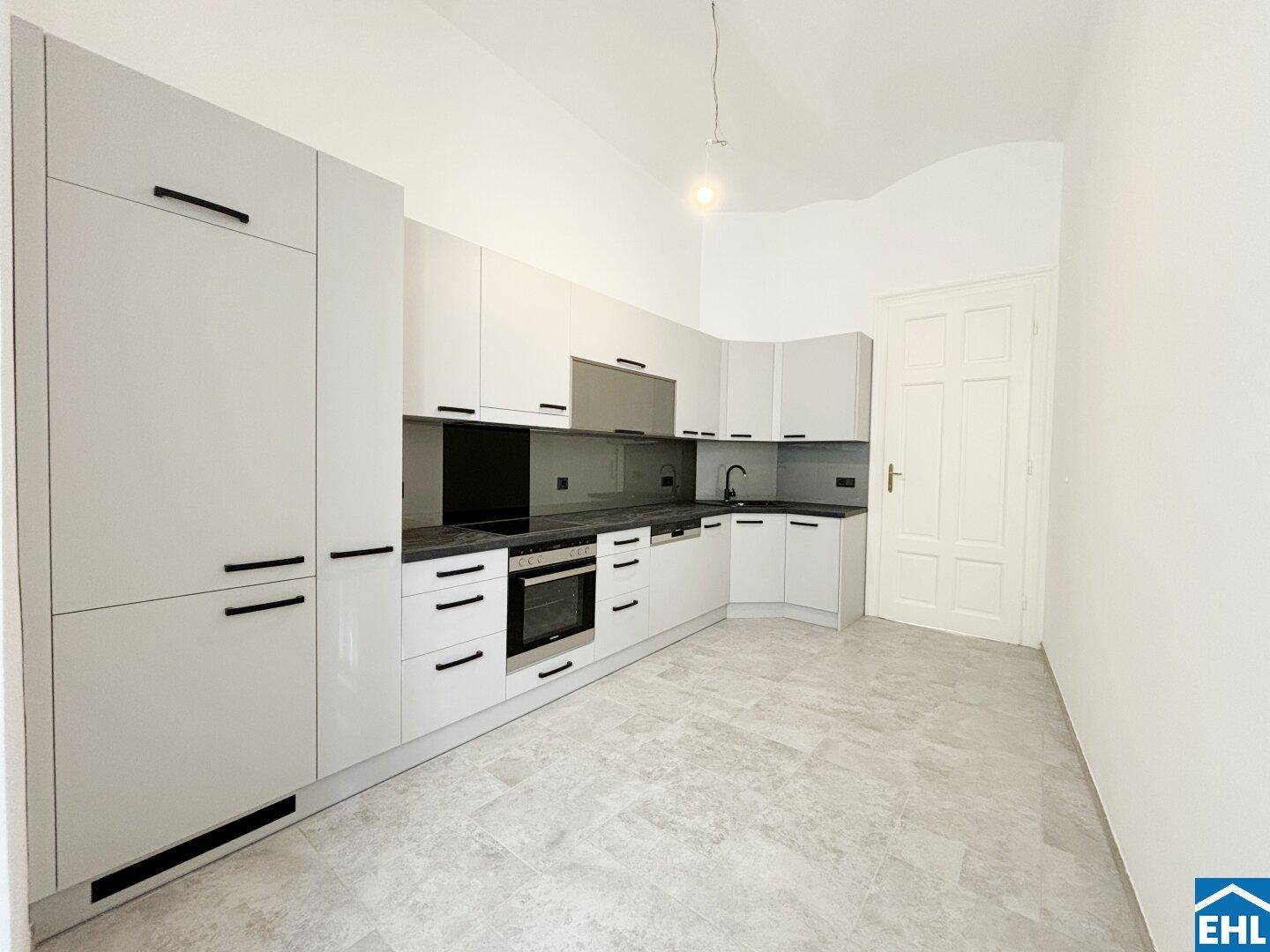 Moderne Einbauküche in hellem Grau mit integrierten Geräten und viel Stauraum, neuwertig und funktional.