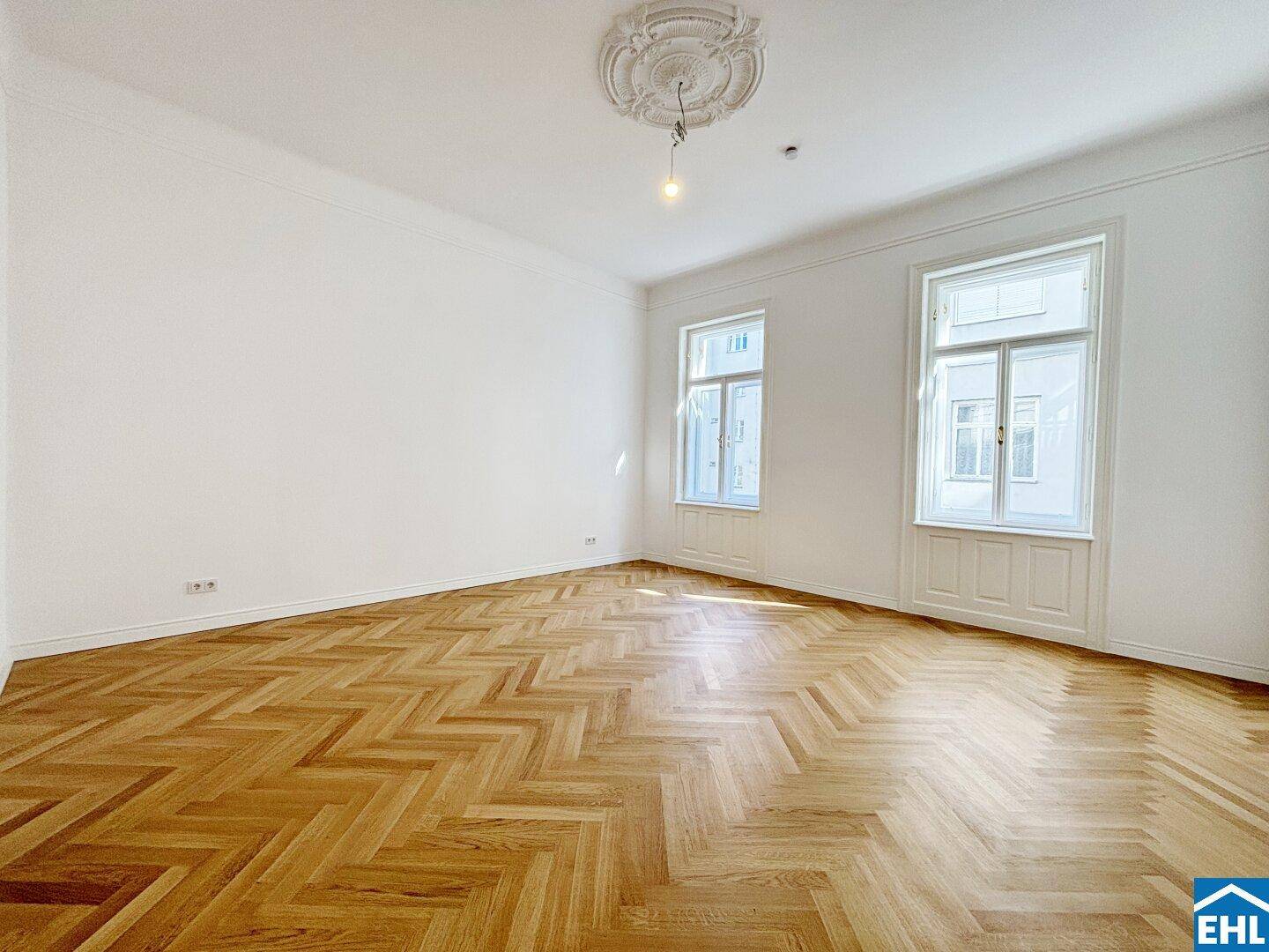 Geräumiges, helles Zimmer mit klassischem Fischgrätparkett und hohen Decken, bereit zur individuellen Gestaltung.