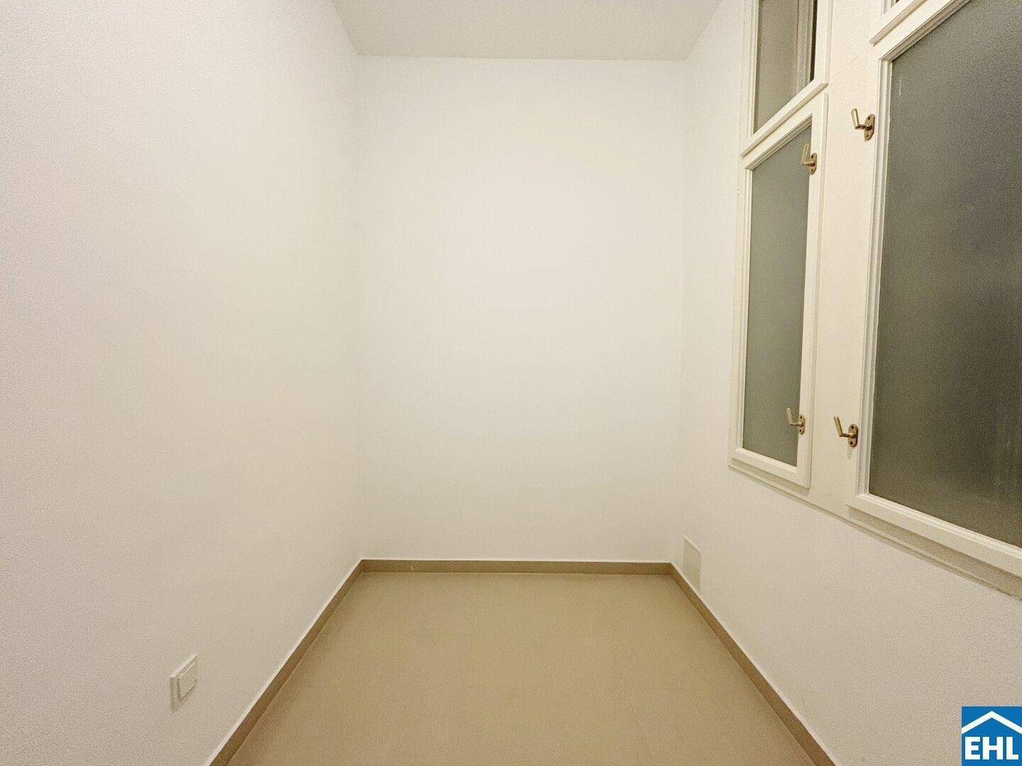 Kleiner, heller Raum mit neutralem Bodenbelag und undurchsichtigen Fenstern.