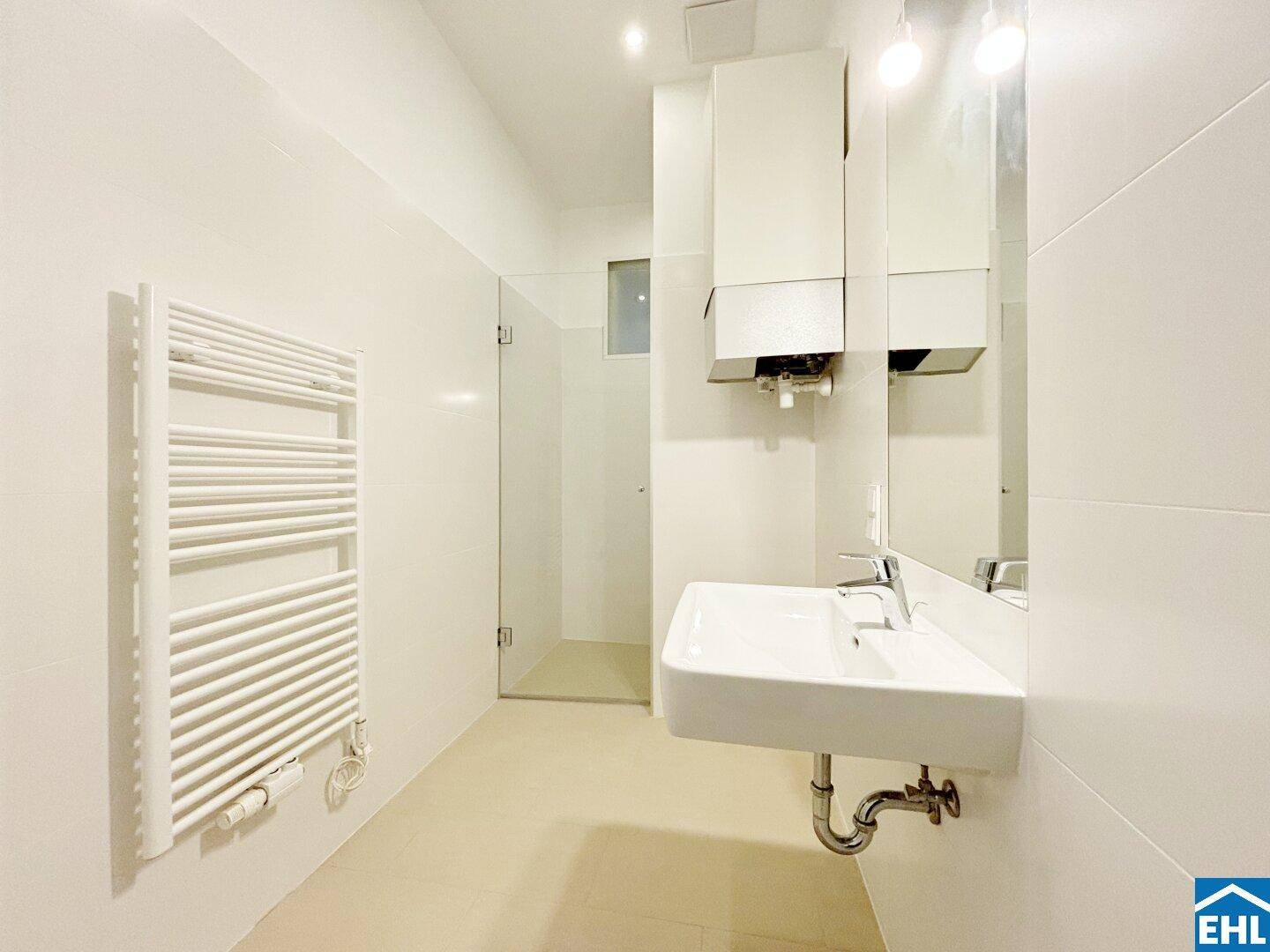 Modernes Badezimmer mit Dusche, Waschbecken und beheiztem Handtuchhalter.