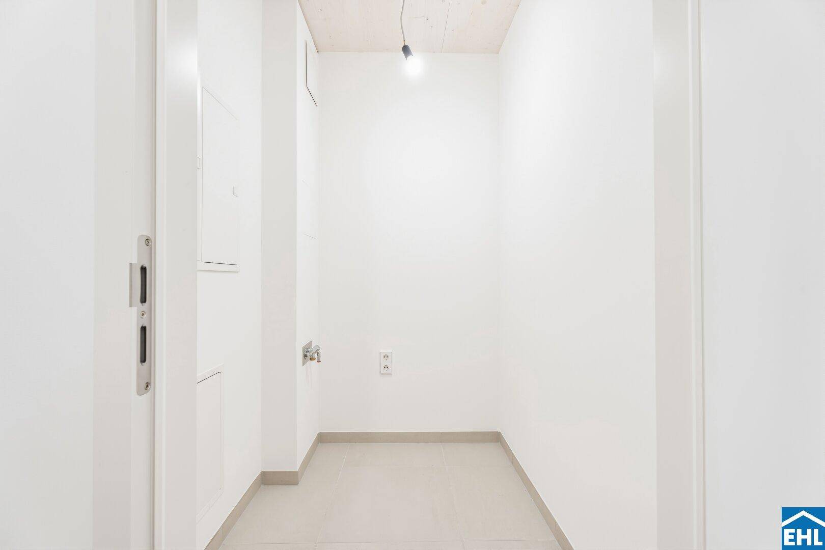Praktischer Hauswirtschaftsraum mit Fliesenboden und Anschlüssen für Waschmaschine und Trockner.