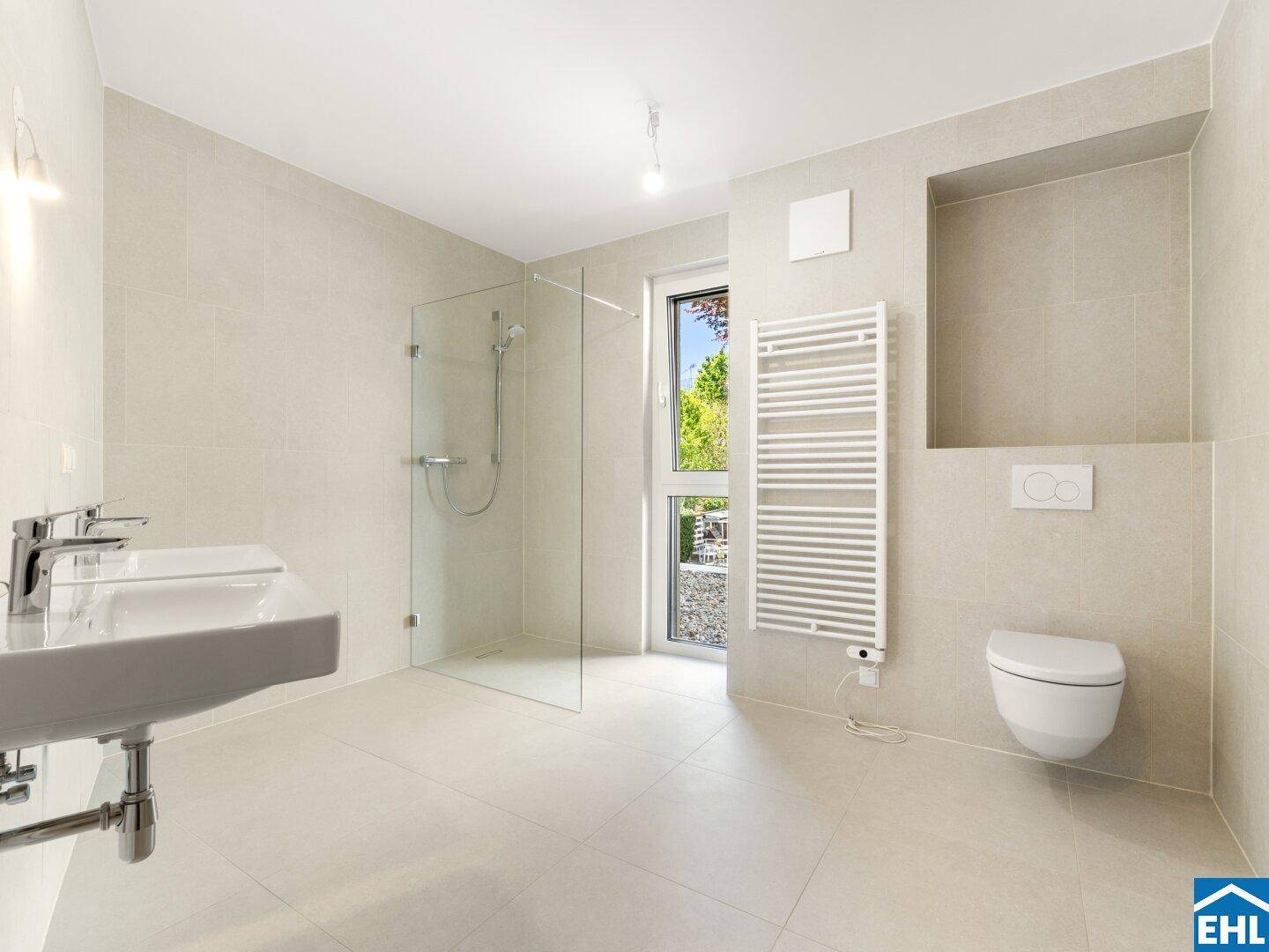 Modernes Badezimmer mit begehbarer Dusche, wandhängendem WC und beheiztem Handtuchhalter.