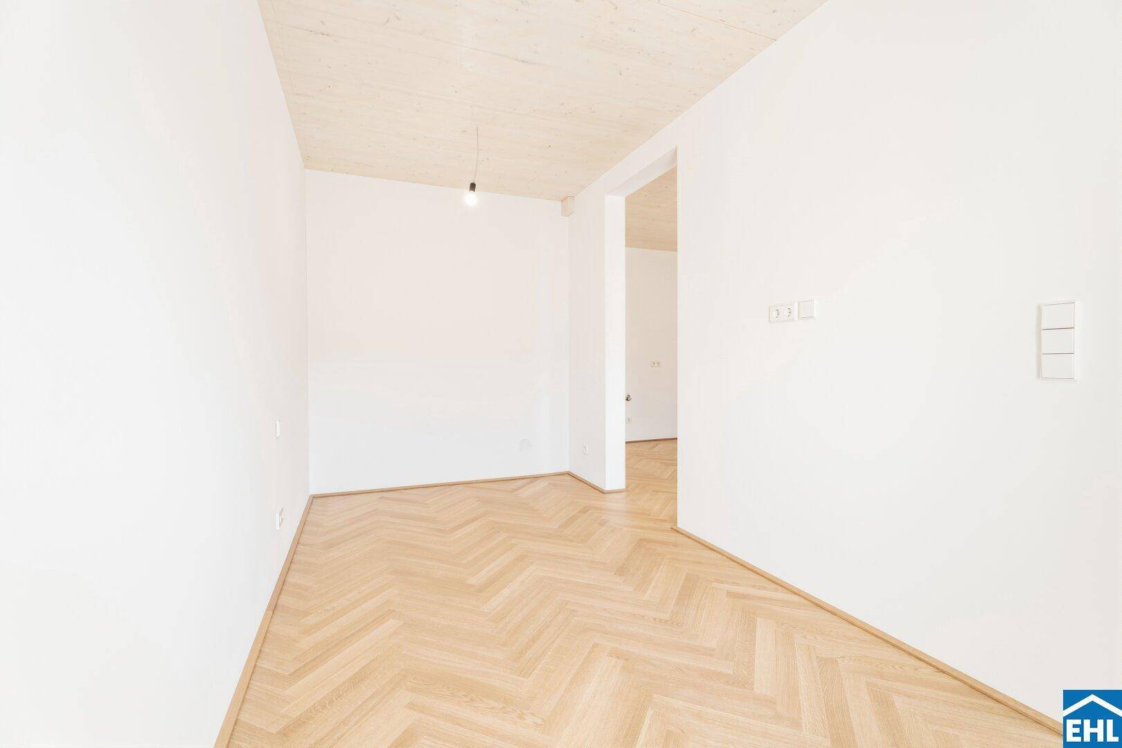 Unmöblierter Raum mit Fischgrätparkett und weiß gestrichenen Wänden, bereit zum Einzug.