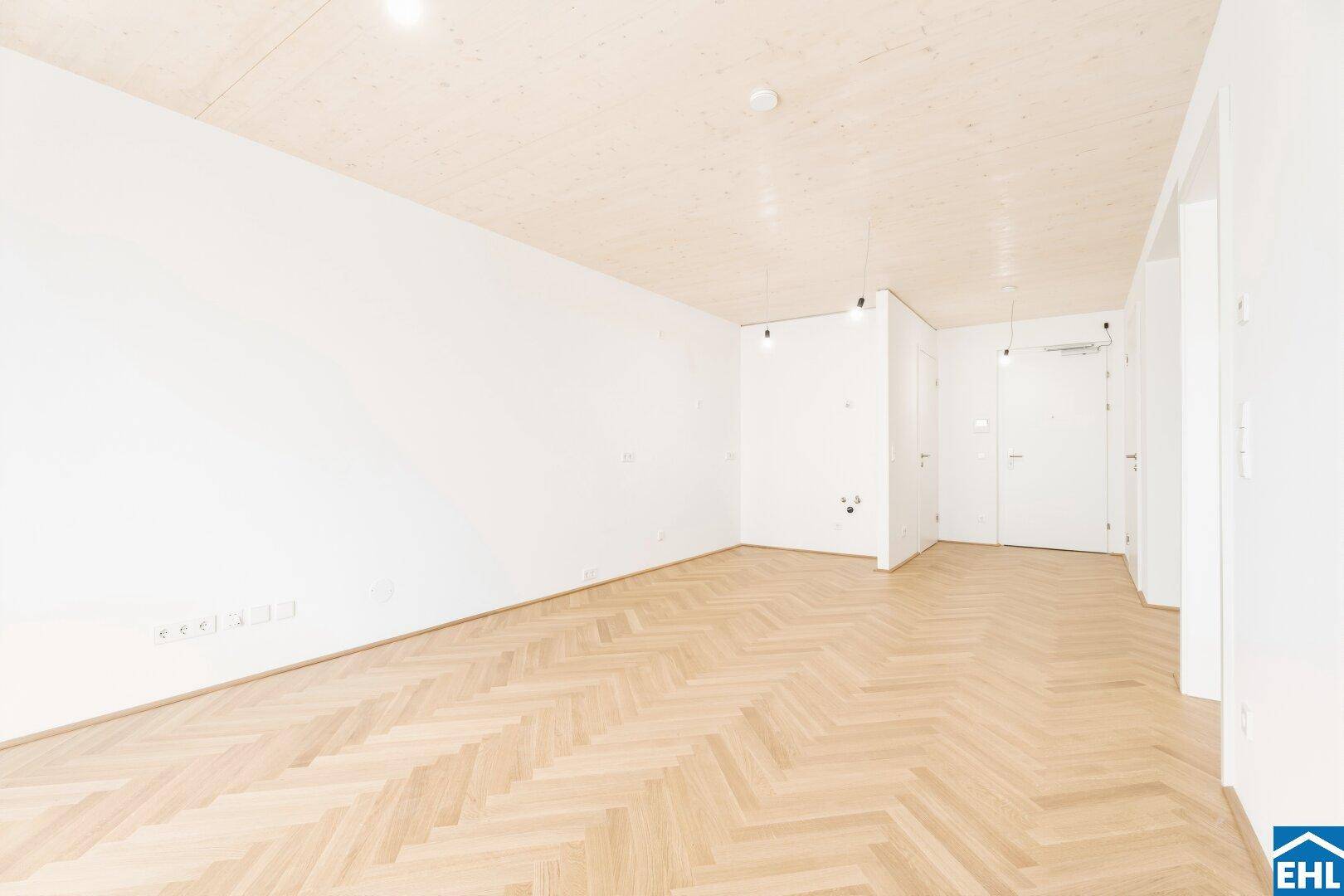 Leerer Flur mit hellem Fischgrätparkett und weiß gestrichenen Wänden, ideal für moderne Wohnkonzepte.