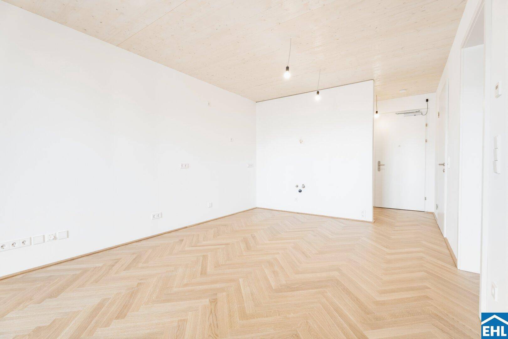 Heller Raum mit Fischgrätparkett und Holzbalkendecke, ideal für individuelle Gestaltung.