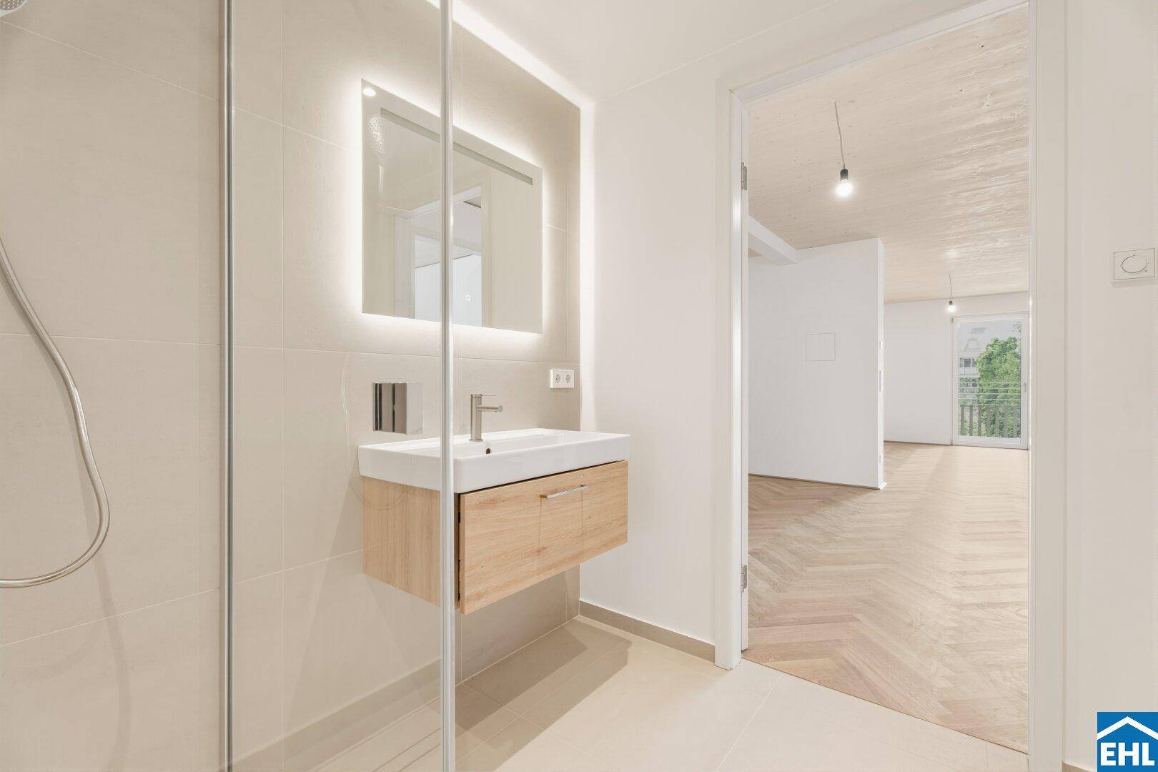 Modernes Badezimmer mit begehbarer Dusche und Blick in den angrenzenden Wohnbereich.
