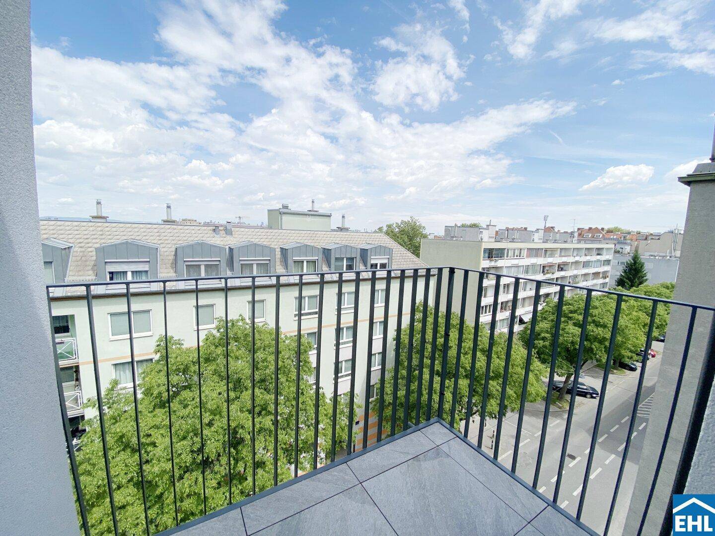 Balkon mit Metallgeländer und Blick auf die umliegenden Gebäude und die Stadtlandschaft.