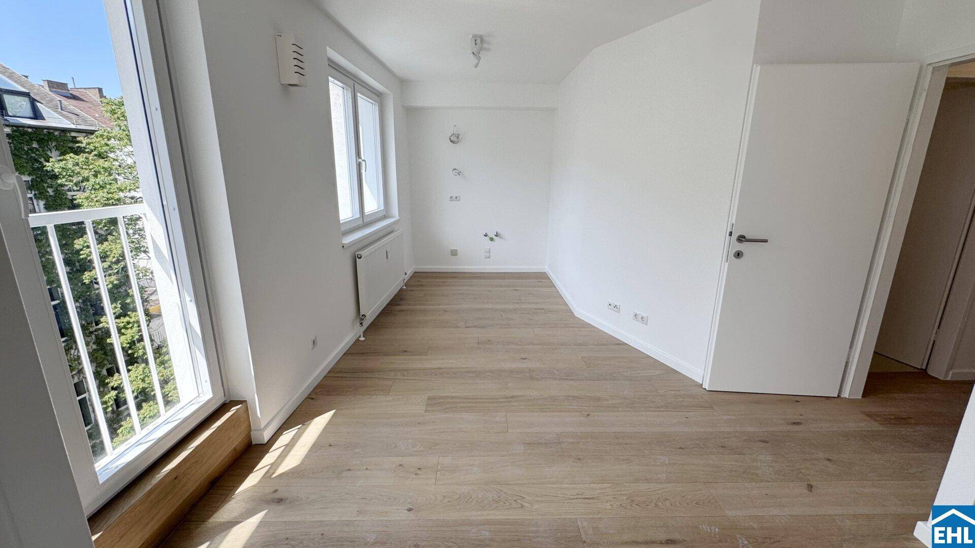 Lichtdurchfluteter Raum mit Holzboden, weißen Wänden und einem angenehmen Blick ins Grüne.