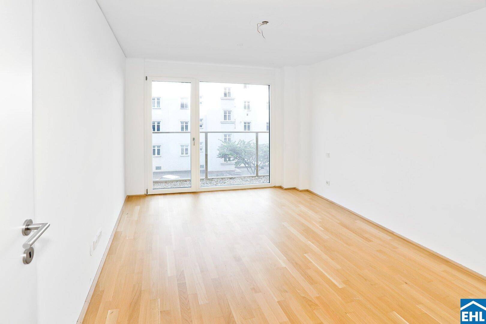 Helles Schlafzimmer mit Parkettboden und direktem Zugang zu einem kleinen Außenbereich.