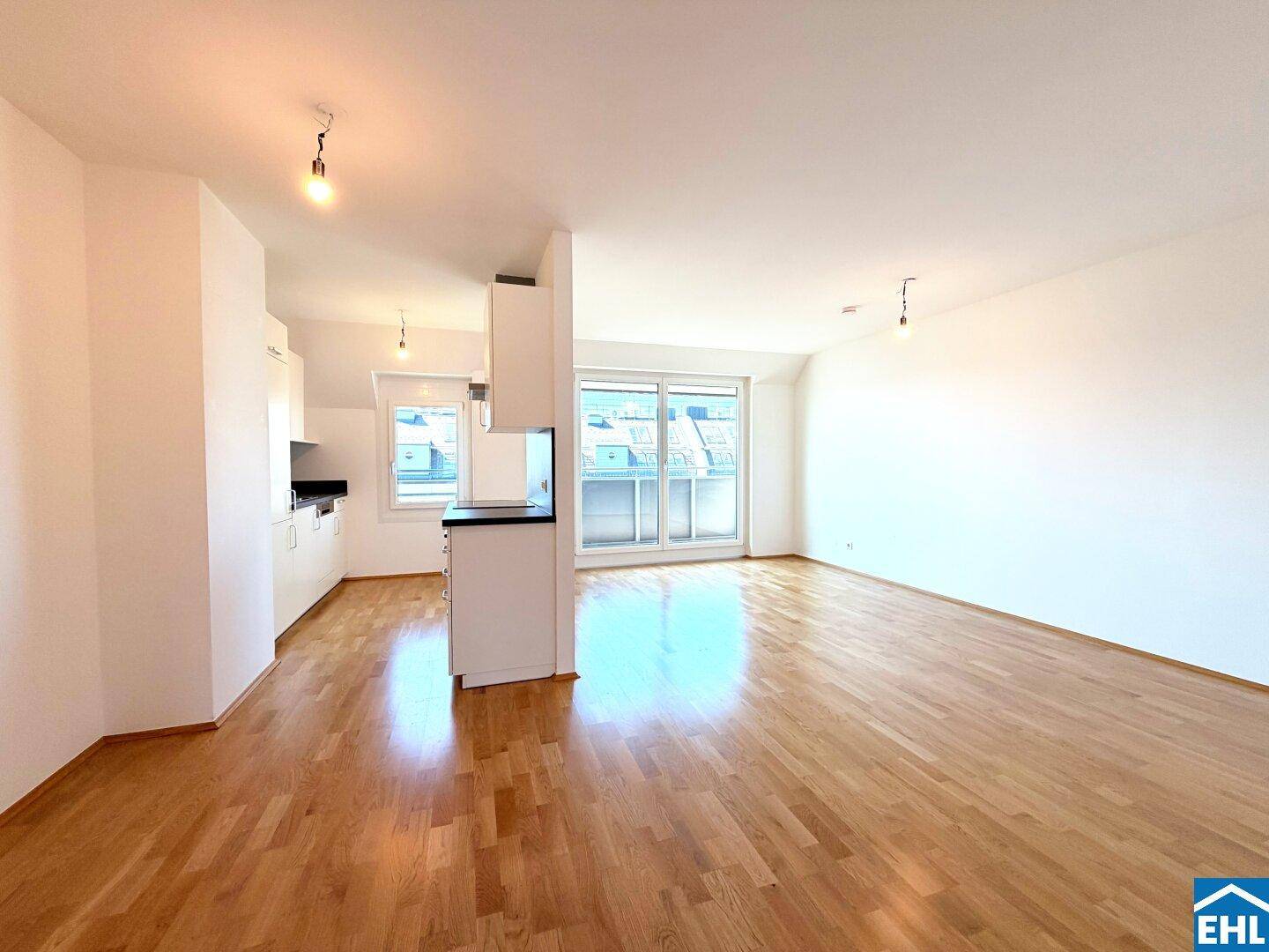 Lichtdurchfluteter offener Wohnbereich mit Zugang zum Balkon und Parkettboden.