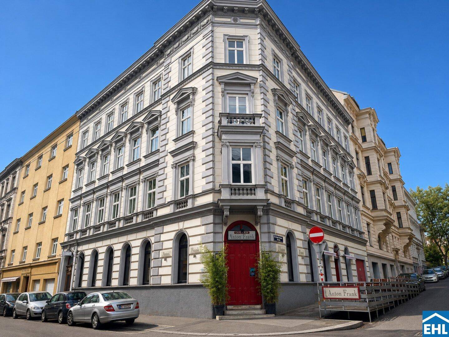 Historisches Eckgebäude mit aufwendiger Fassade und vielen Fenstern in einer städtischen Umgebung.