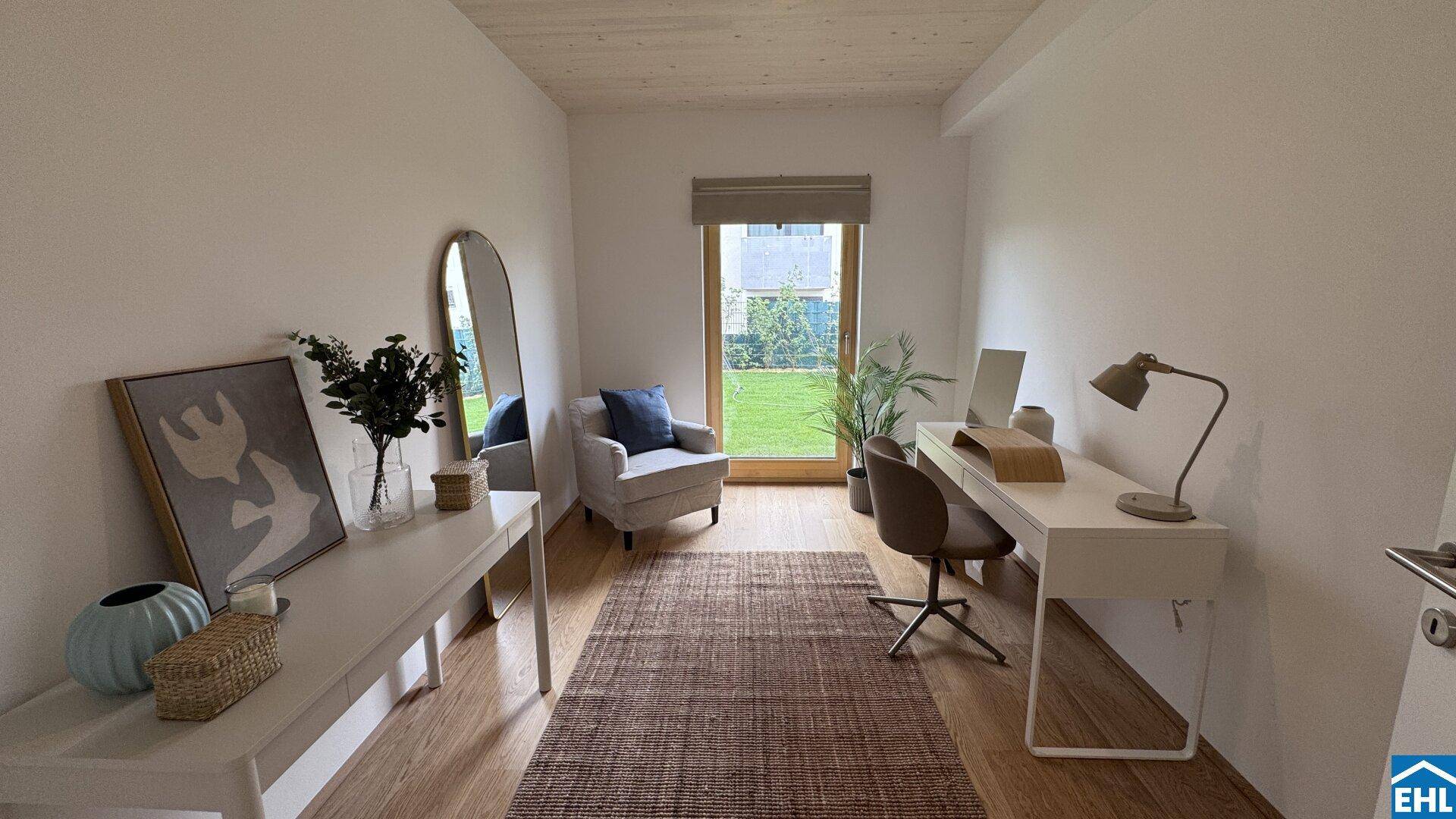 Lichtdurchflutetes Arbeitszimmer mit Schreibtisch, Sessel und direktem Gartenzugang.