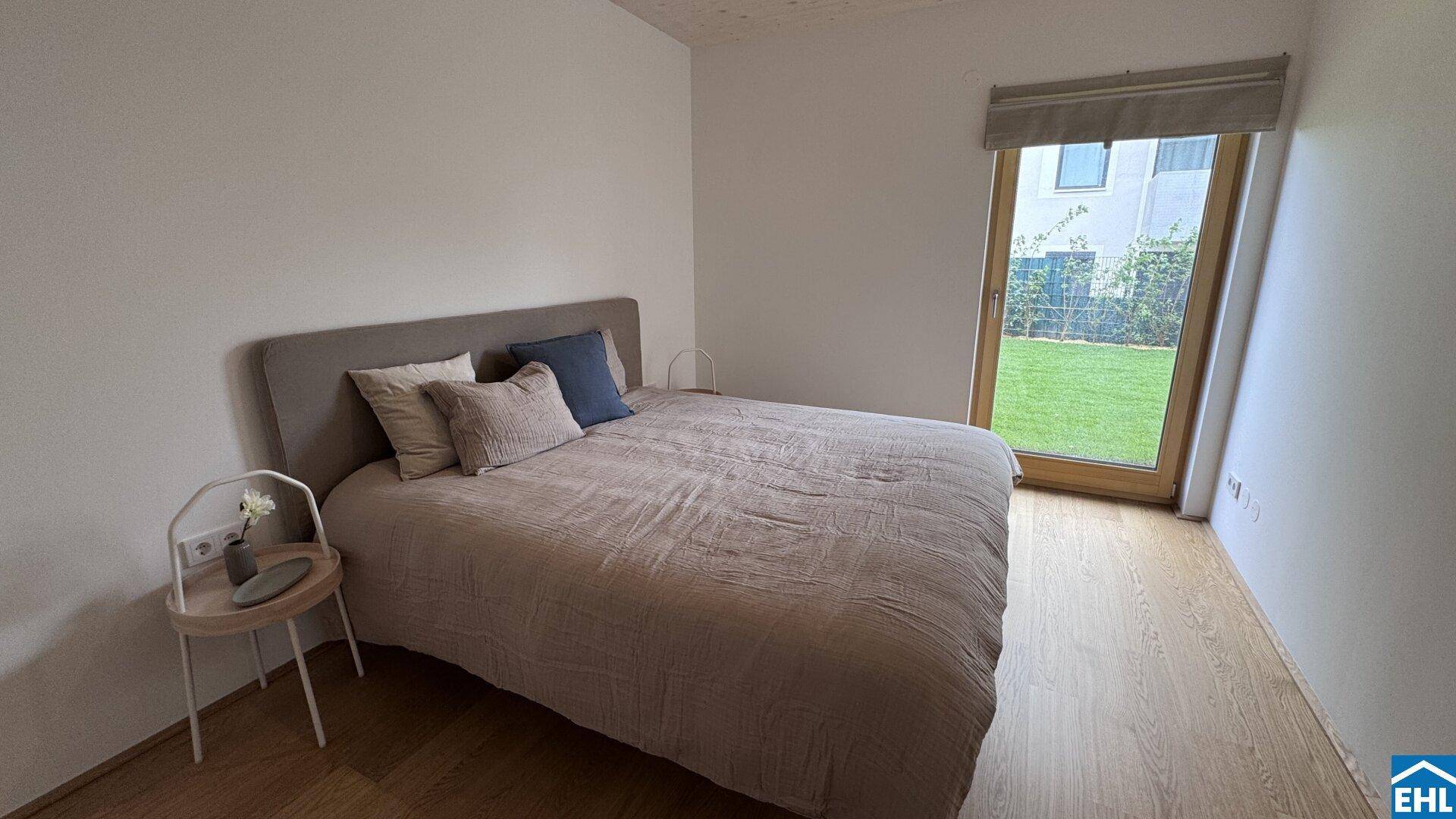Gemütliches Schlafzimmer mit Doppelbett, Holzboden und direktem Gartenzugang.