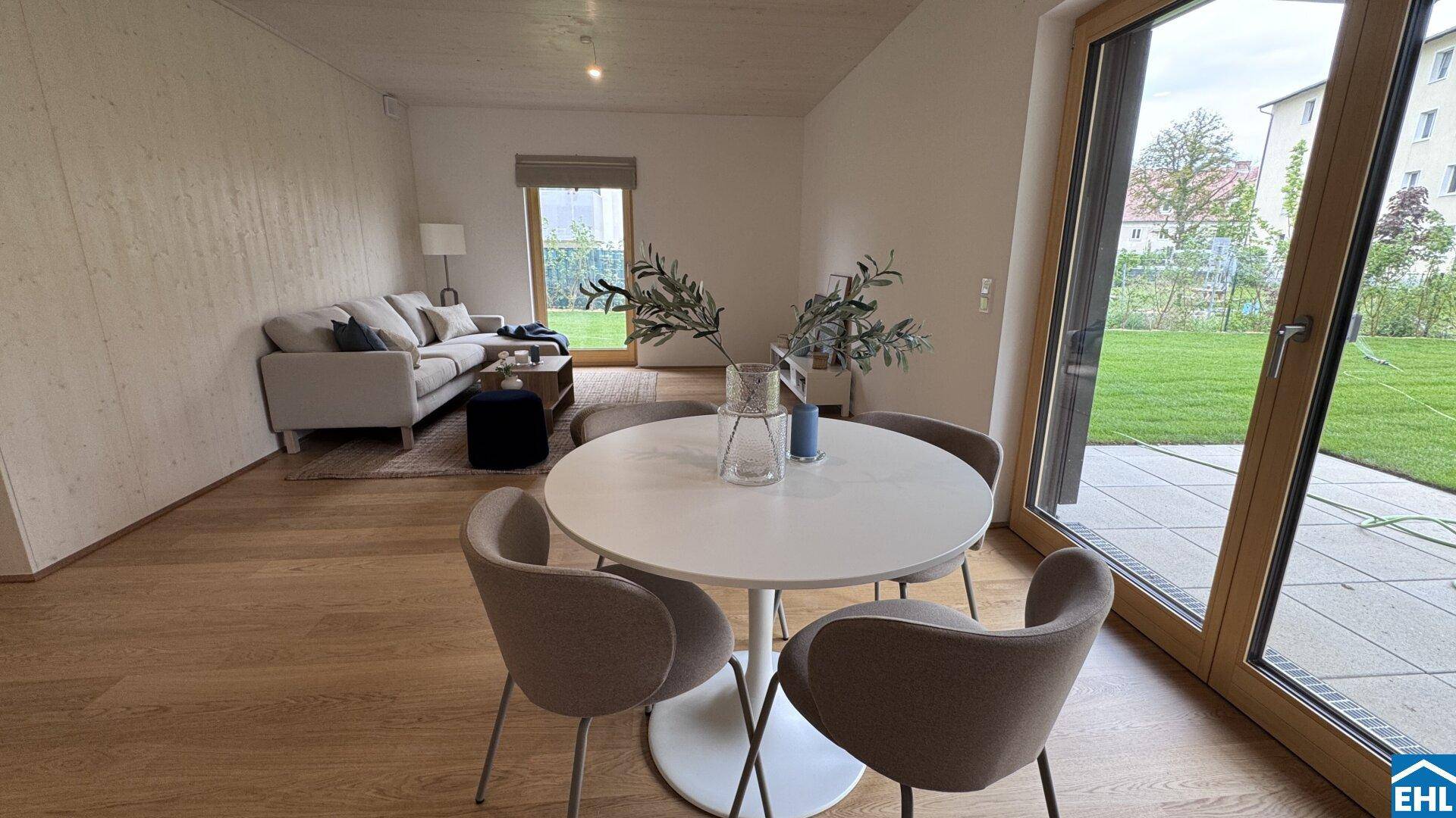 Geräumiger Wohn- und Essbereich mit Holzboden und direktem Zugang zum Garten.