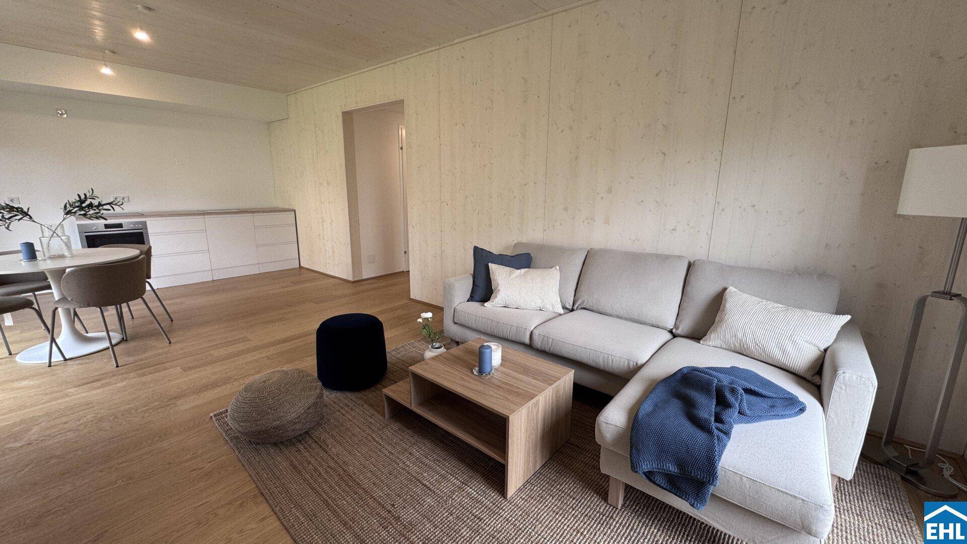 Gemütliches Wohnzimmer mit Ecksofa, Holzboden und offener Gestaltung.