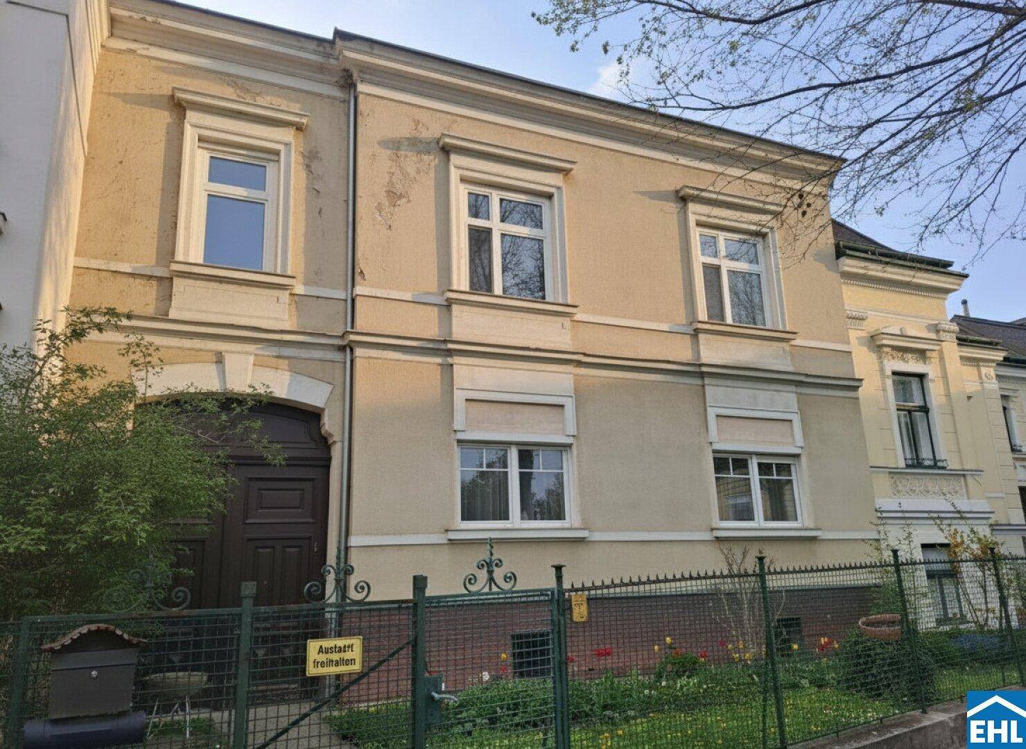 Historische Fassade eines Mehrfamilienhauses mit klassischen Fenstern und einem markanten Eingangsbereich.