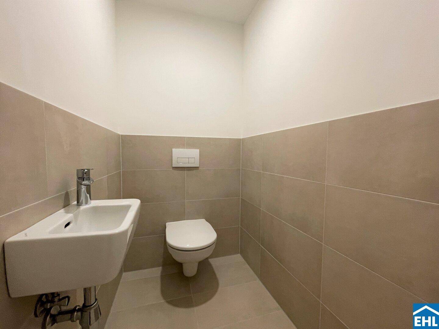 Separates Gäste-WC mit modernem Waschbecken und Wand-WC in schlichtem, funktionalem Design.