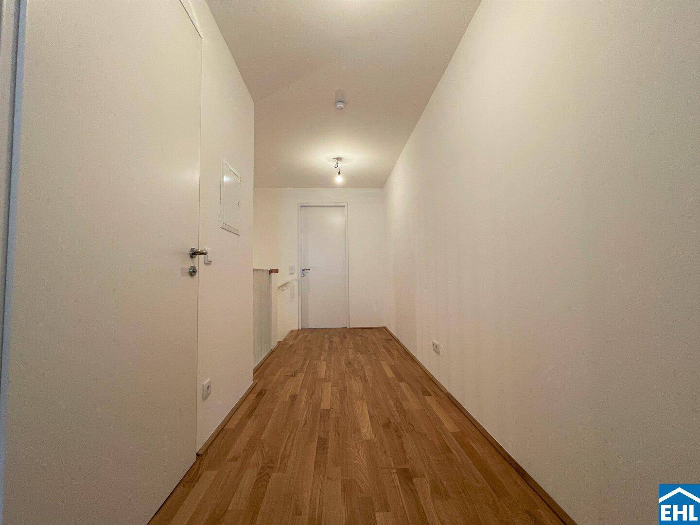 Heller Flur mit Holzboden und Zugang zu den verschiedenen Räumen der Wohnung.