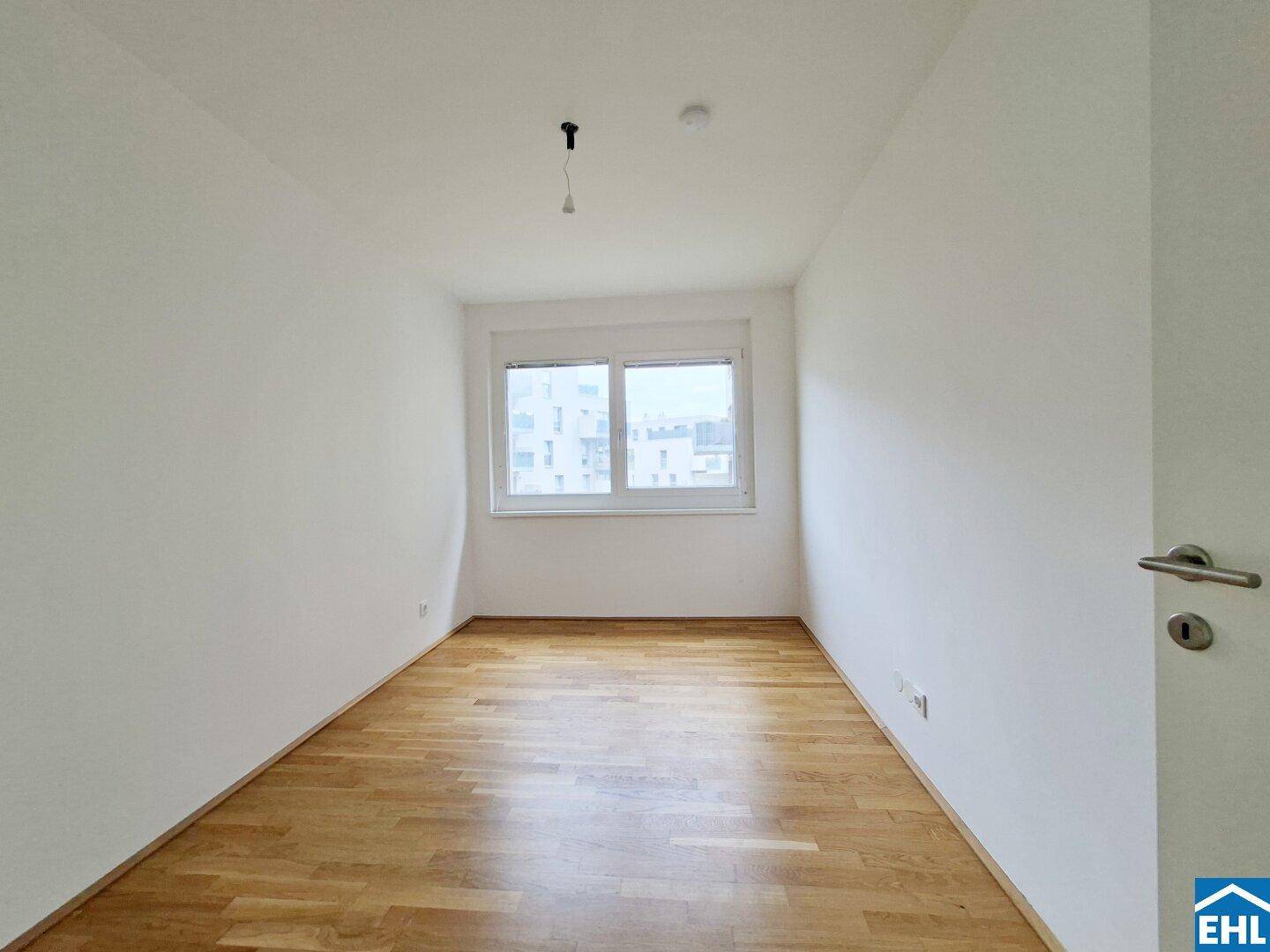 Ruhiges Schlafzimmer mit Parkettboden und Fenster, bietet viel Tageslicht.