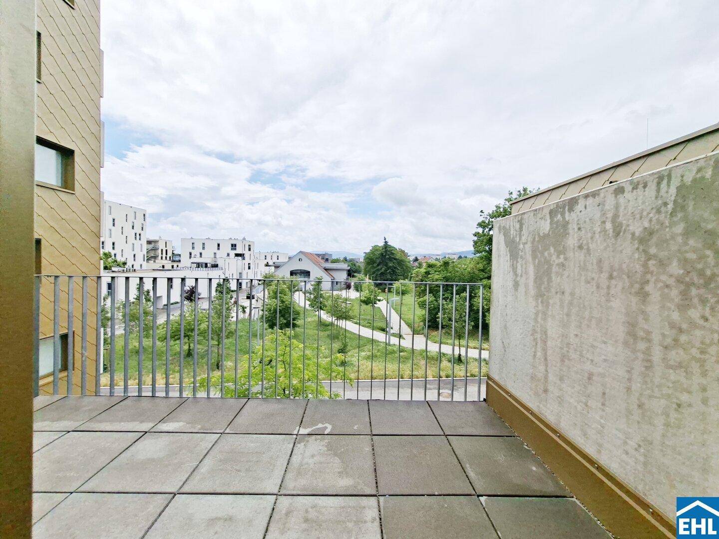 Geräumiger Balkon mit Fliesenboden und Blick ins Grüne, ideal zum Entspannen.