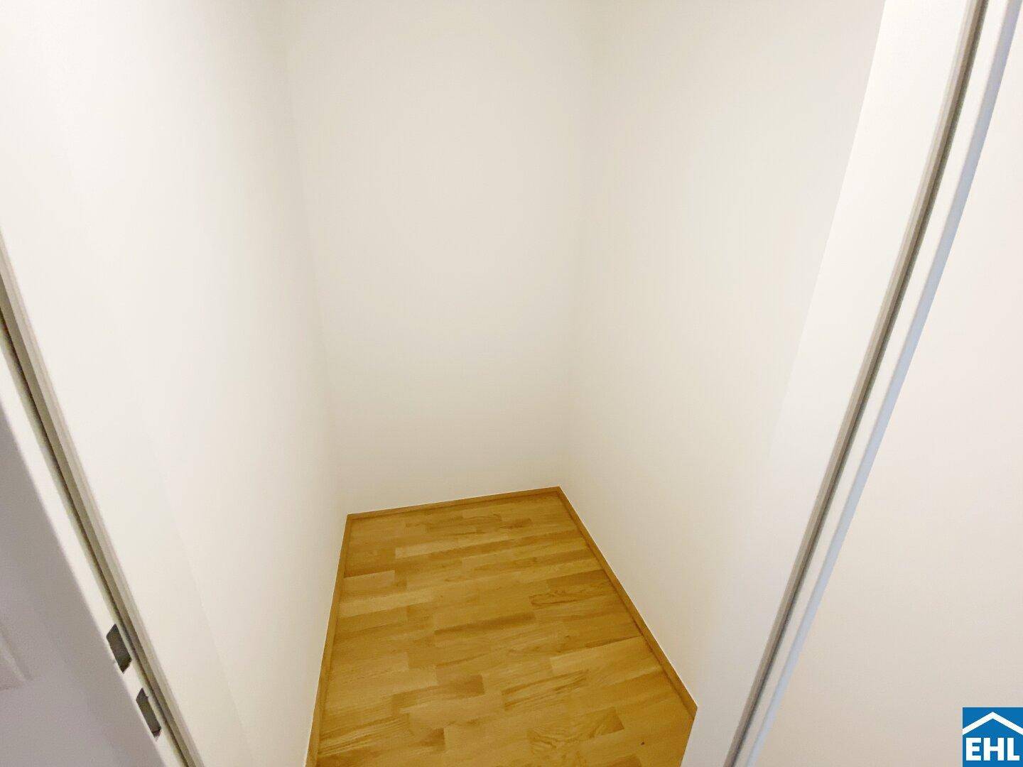 Kleiner Abstellraum mit hellem Parkettboden und weißen Wänden.