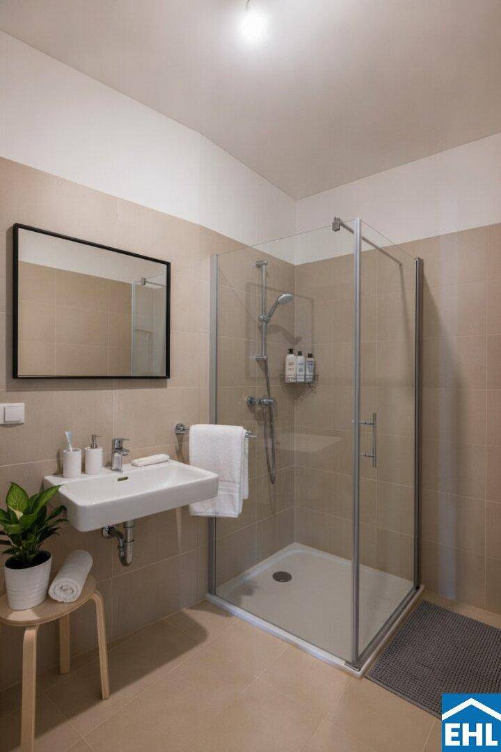 Modernes Badezimmer mit Duschkabine, Einzelwaschbecken und beigefarbenen Fliesen.