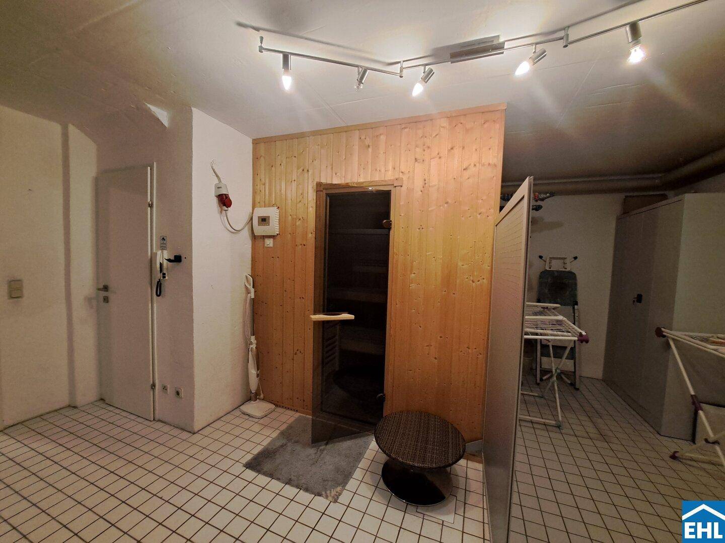 Kellerraum mit integrierter Sauna, Fliesenboden und praktischen Abstellmöglichkeiten.