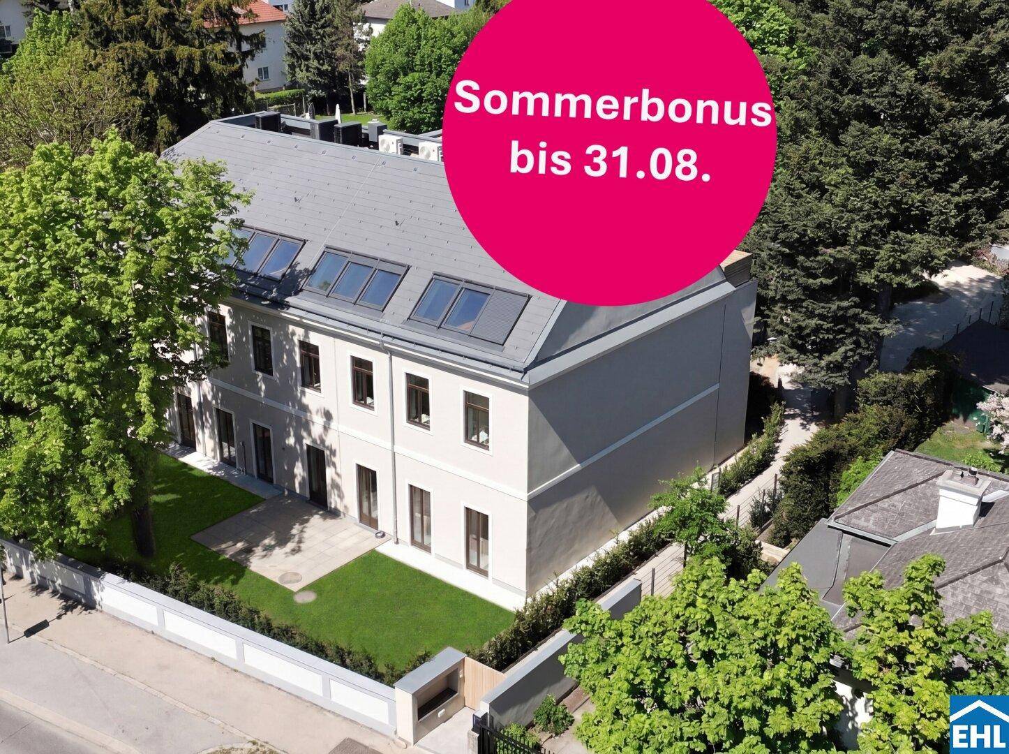 Luftaufnahme eines modernen Gebäudes mit gepflegtem Garten und vielen Bäumen in der Umgebung.