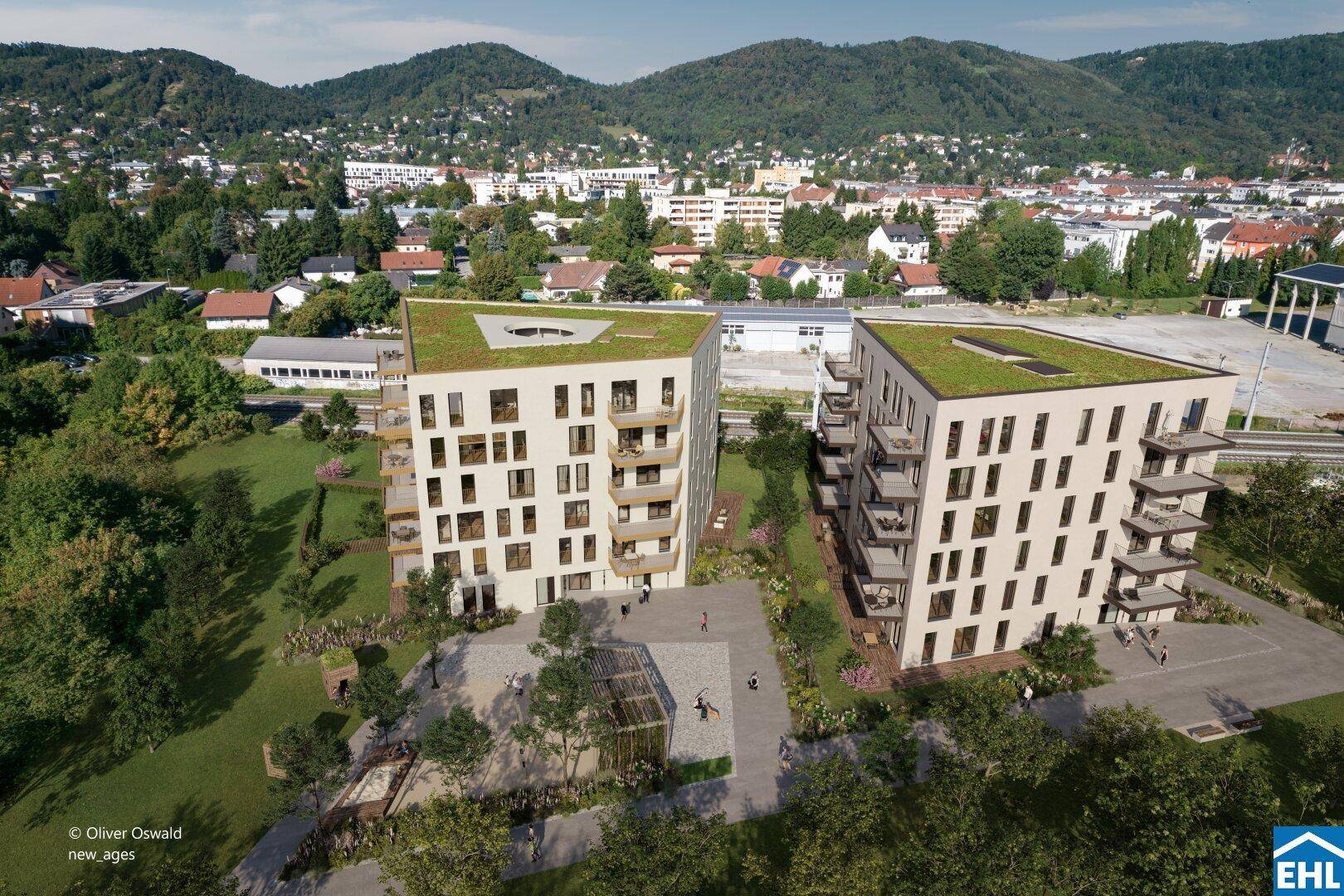 Moderne Wohngebäude mit Gründächern und Balkonen, eingebettet in eine grüne Umgebung mit Hügeln im Hintergrund.